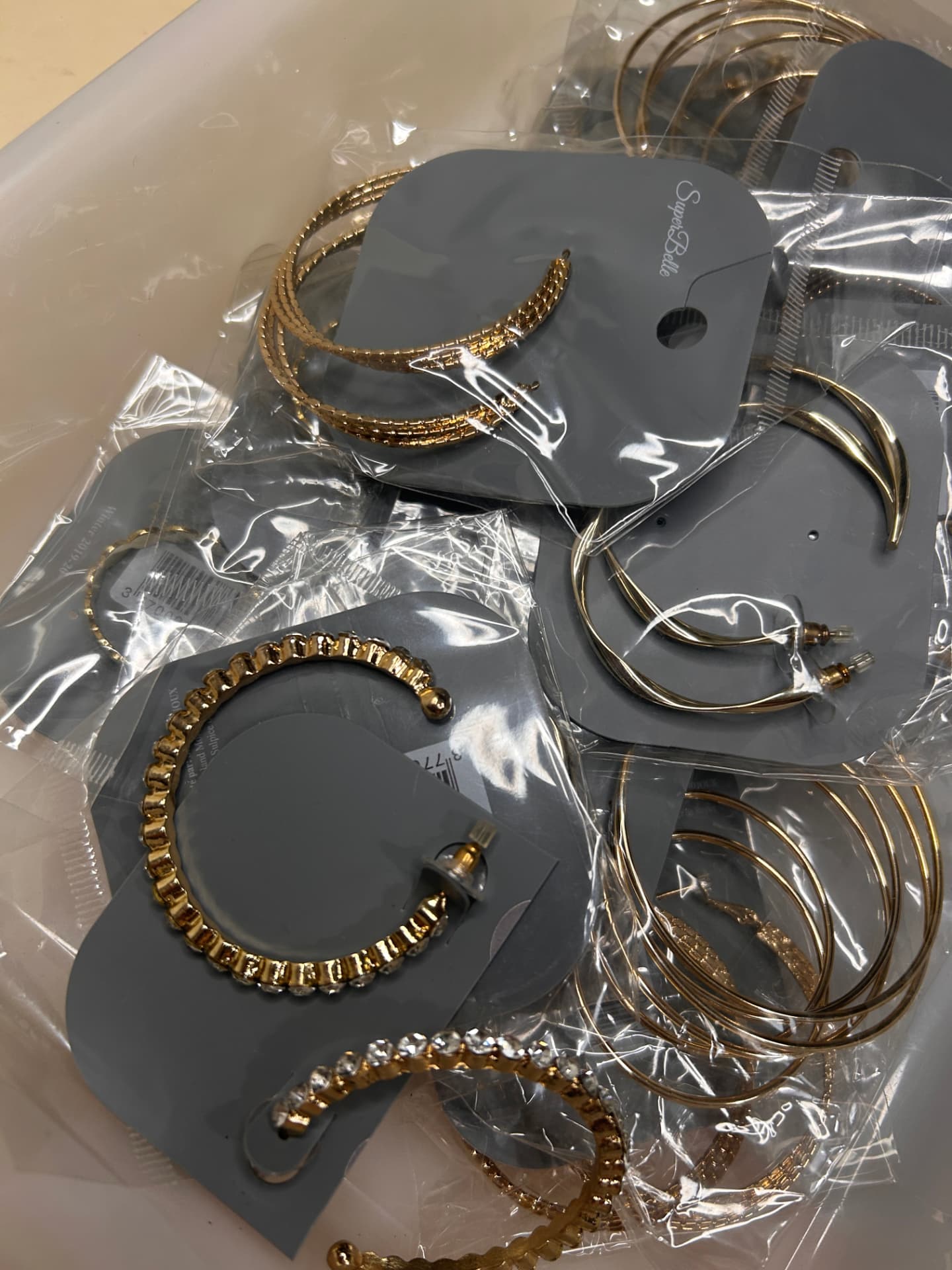 Primer plano de aros con strass escalonados y embalaje marca SuperBelle