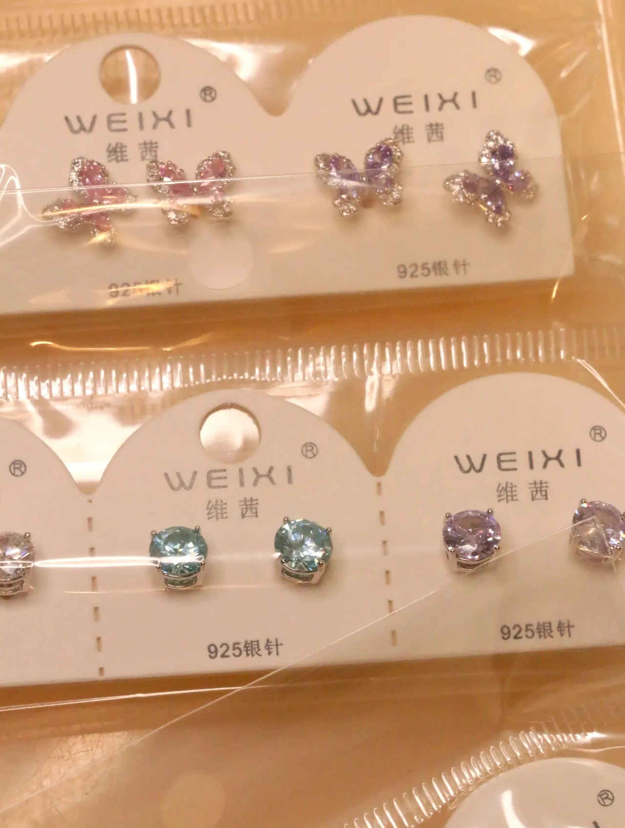 Pendientes de mariposa rosas y lilas junto a modelos redondos — lote de pendientes online, vista principal · Lotes Bisutería (0017)