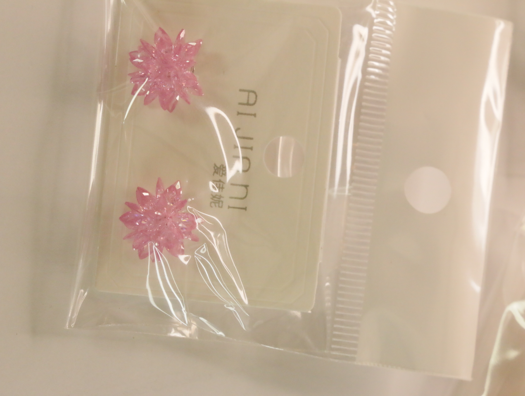Detalle de pendientes florales rosas sobre tarjeta — lote de bisutería de moda, vista lateral · Lotes Bisutería (100)
