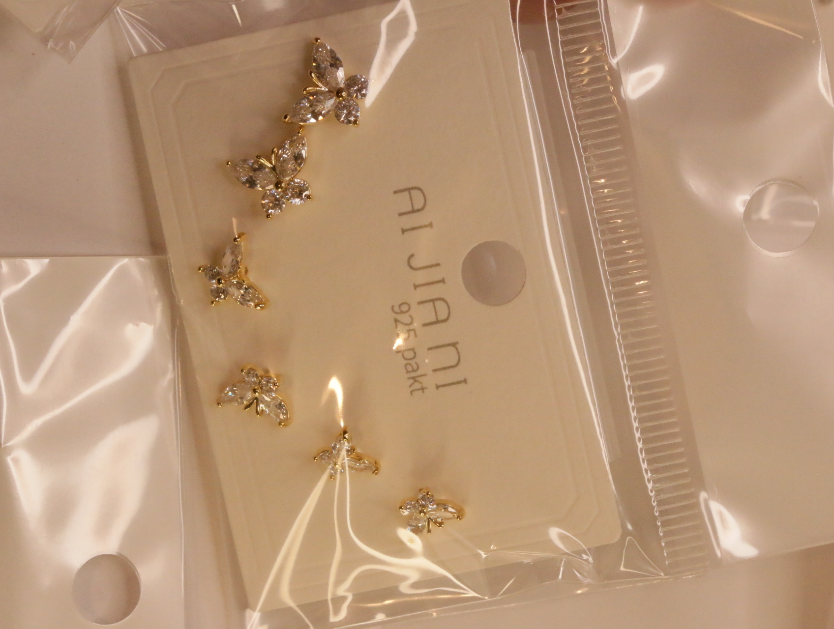 Detalle de pendientes florales con adornos brillantes — lote de bisutería de moda, vista lateral · Lotes Bisutería (102)