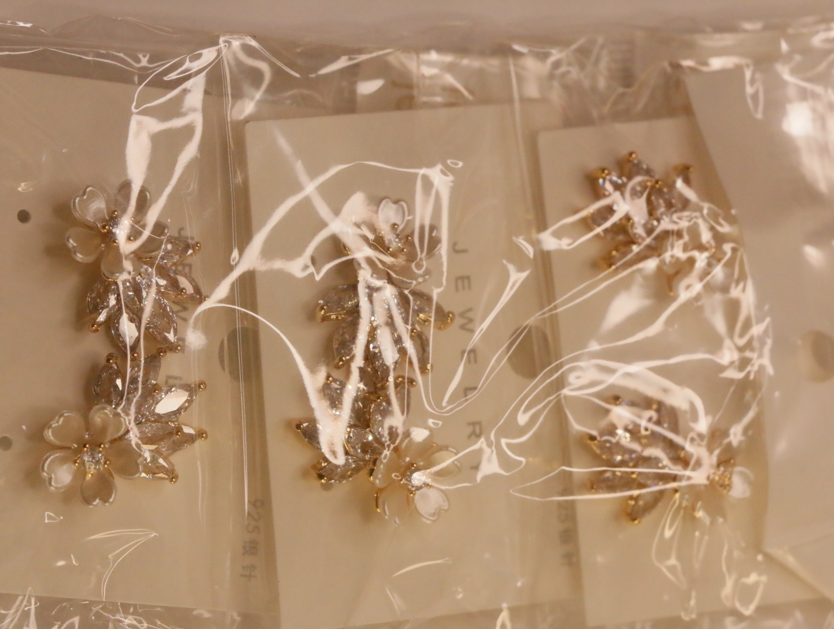 Pendientes florales dorados sobre tarjetas dentro del envoltorio — lote de bisutería dorados, primer plano · Lotes Bisutería (103)