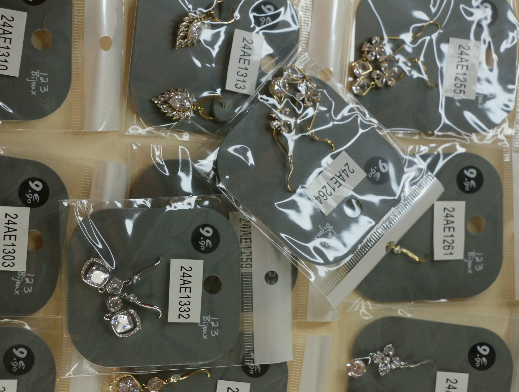 Detalle de pendientes florales y geométricos en bolsas protectoras — lote de bisutería online, vista principal · Lotes Bisutería (119)
