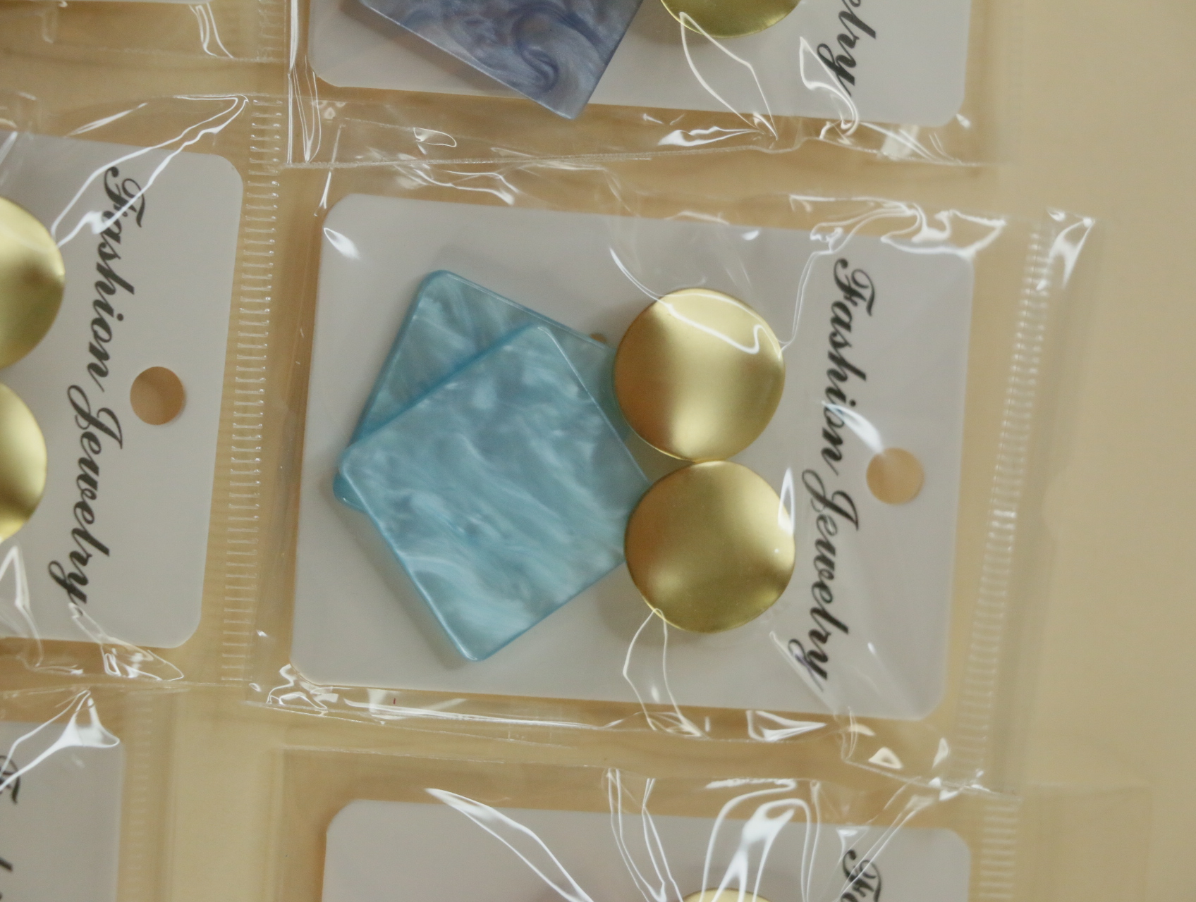 Pendientes geométricos azul claro con parte superior dorada — lote de bisutería dorados, primer plano · Lotes Bisutería (121)
