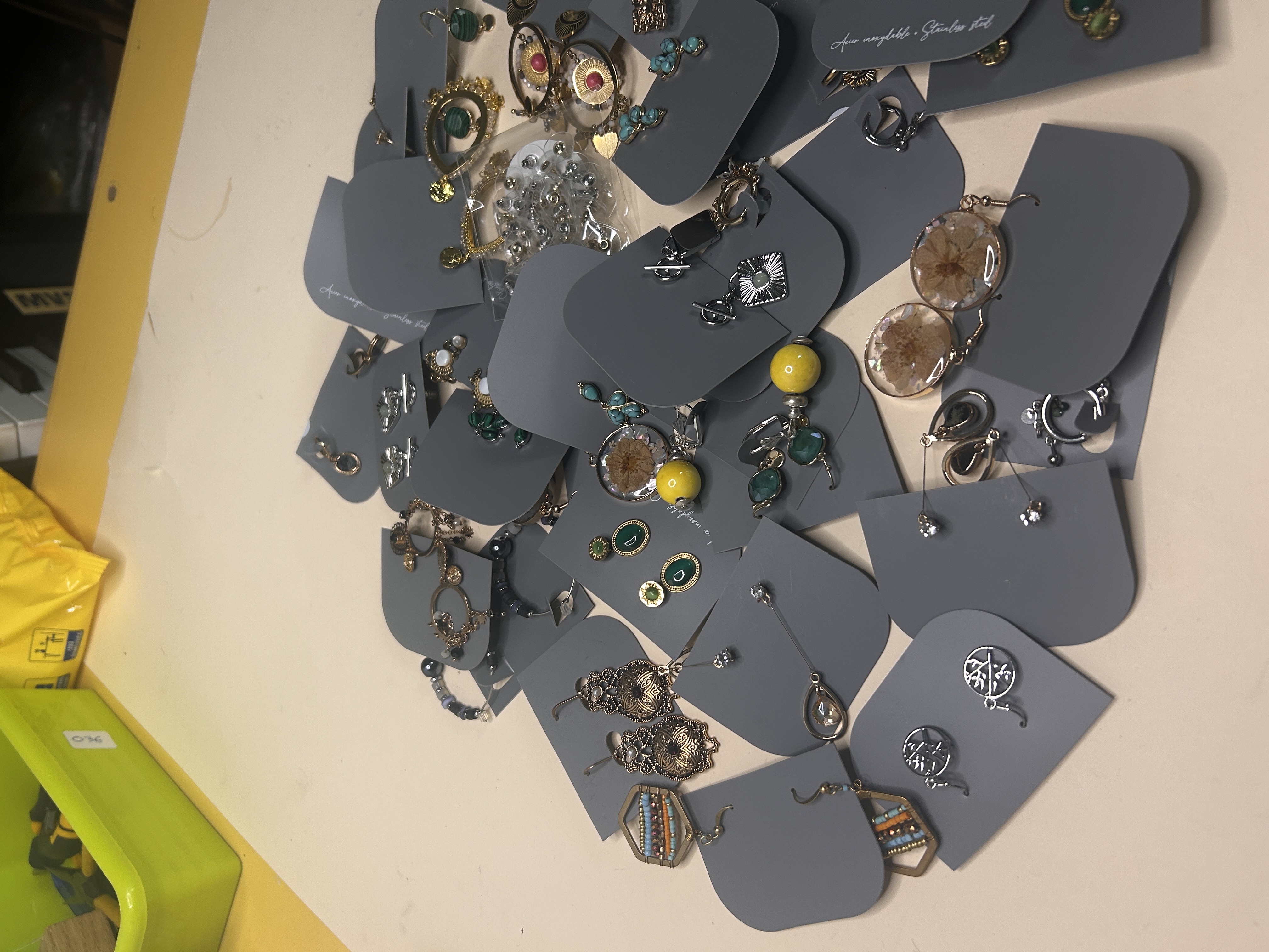 Otra perspectiva en ángulo del surtido de bisutería, mostrando la variedad de formas y materiales como resina, metal y perlas de imitación, con algunas piezas más detalladas.