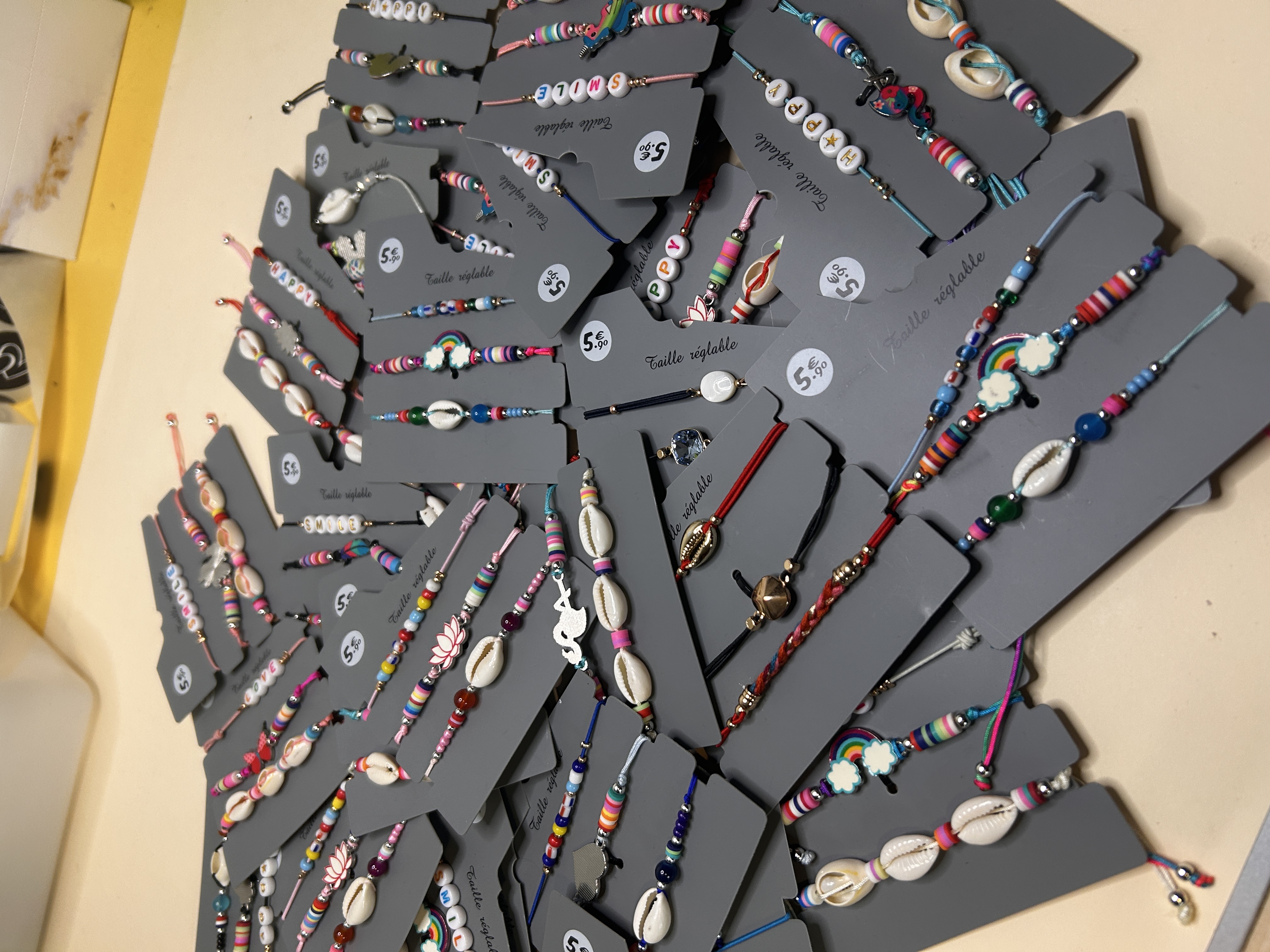 Toma aérea angular de la colección de pulseras coloridas, enfatizando la abundancia y los diversos patrones de la bisutería ajustable.