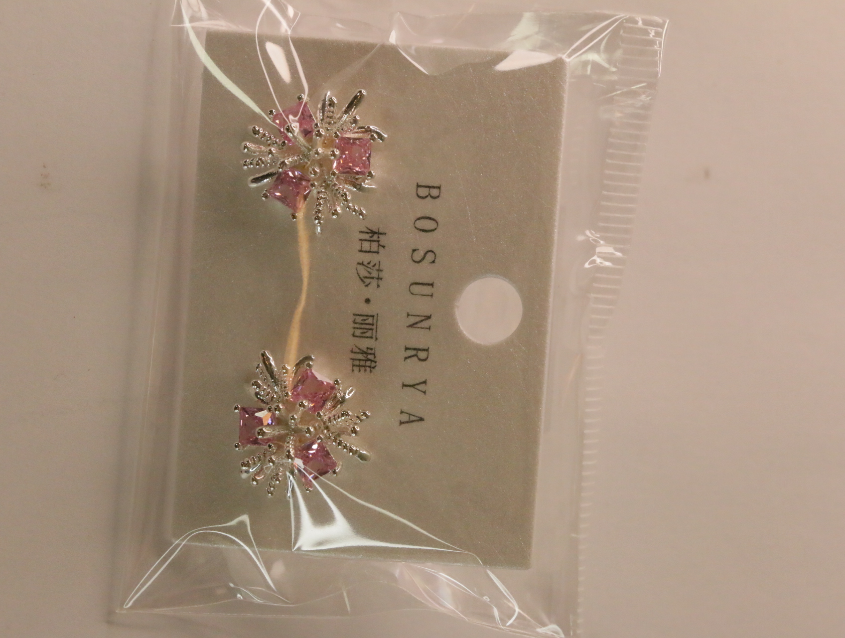 Pendientes florales rosas sobre soporte expositor — lote de bisutería dorados, primer plano · Lotes Bisutería (93)