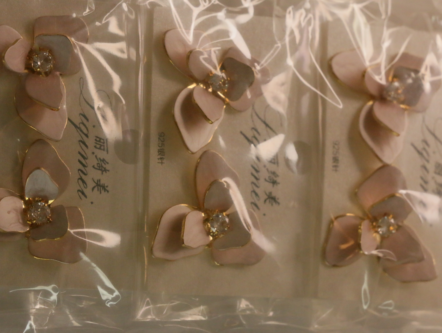 Detalle de pendientes florales rosa empolvado en su envoltorio — lote de bisutería baratos, detalle · Lotes Bisutería (99)