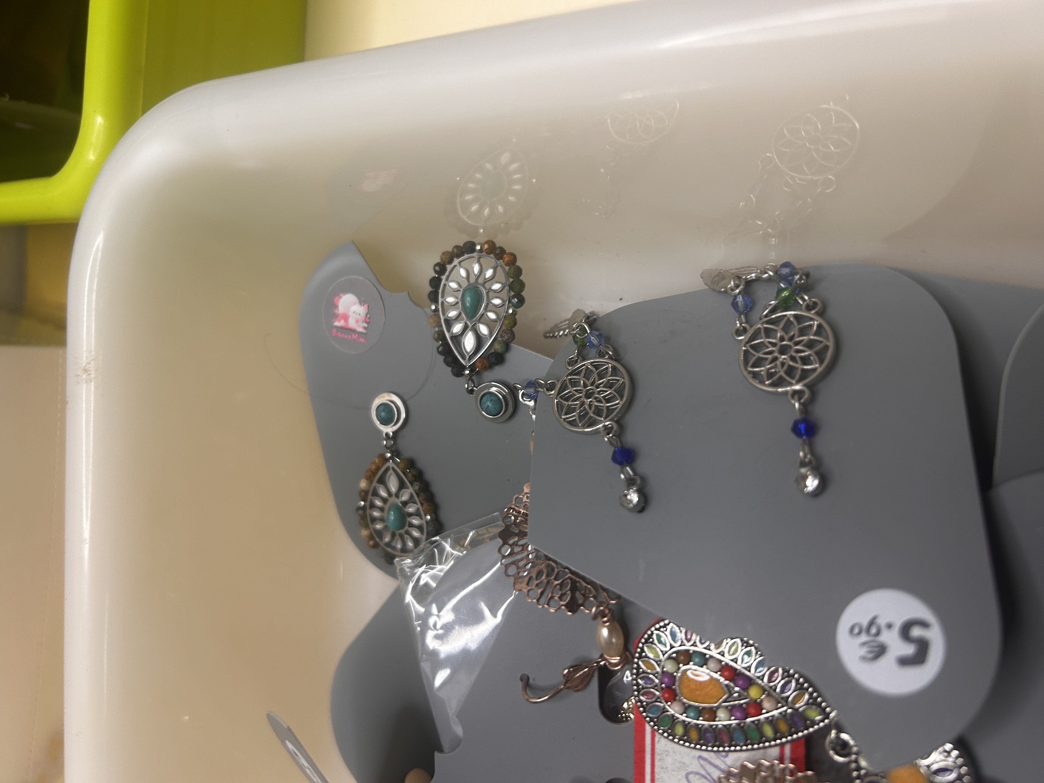 Otro primer plano de pendientes de bisutería con enfoque en diseños bohemios y de atrapasueños, con acentos tipo turquesa y patrones delicados.