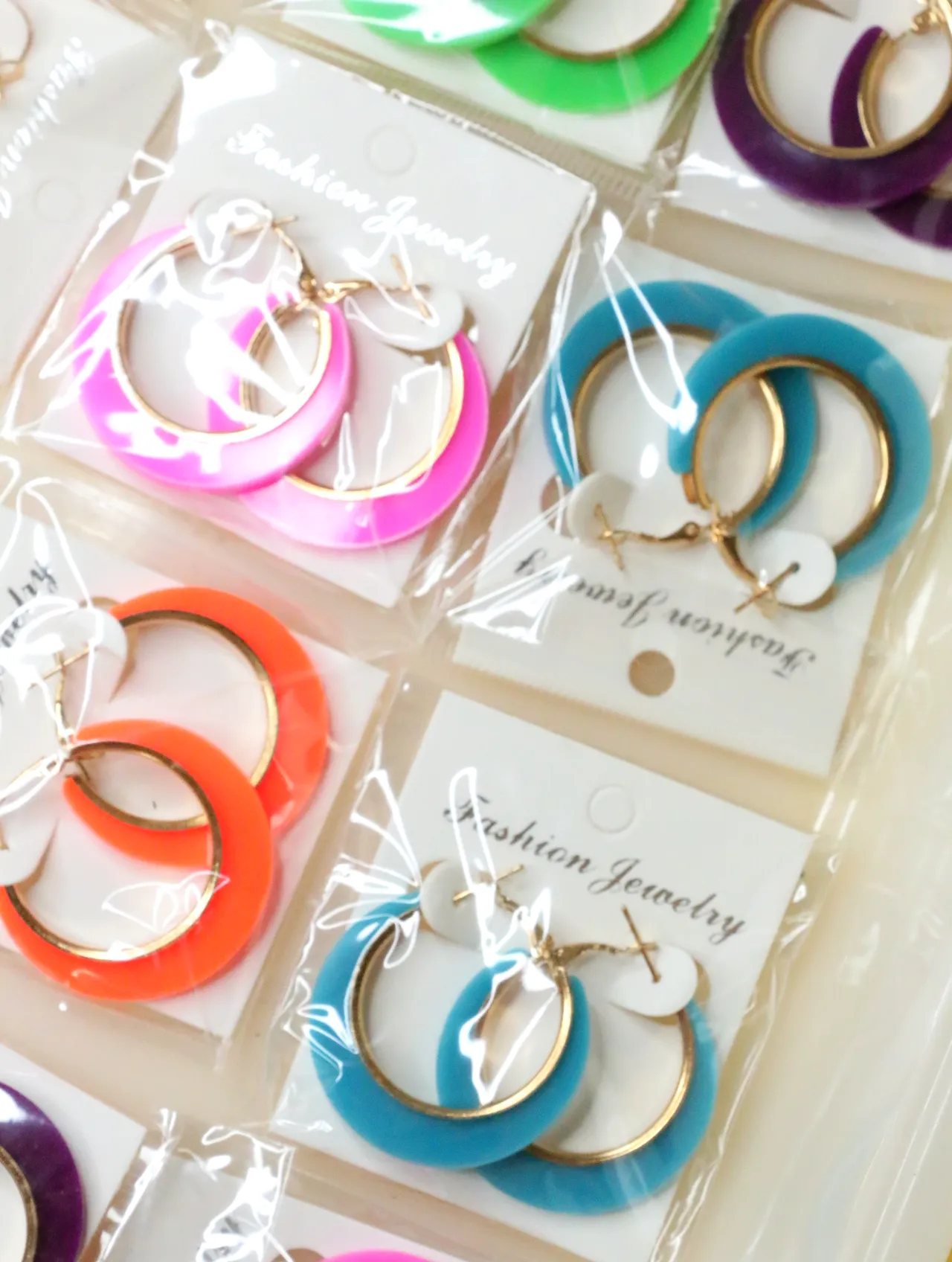 Detalle de aros de colores con acabado dorado — lote de bisutería de moda, vista lateral · Lotes Bisutería (H0007)