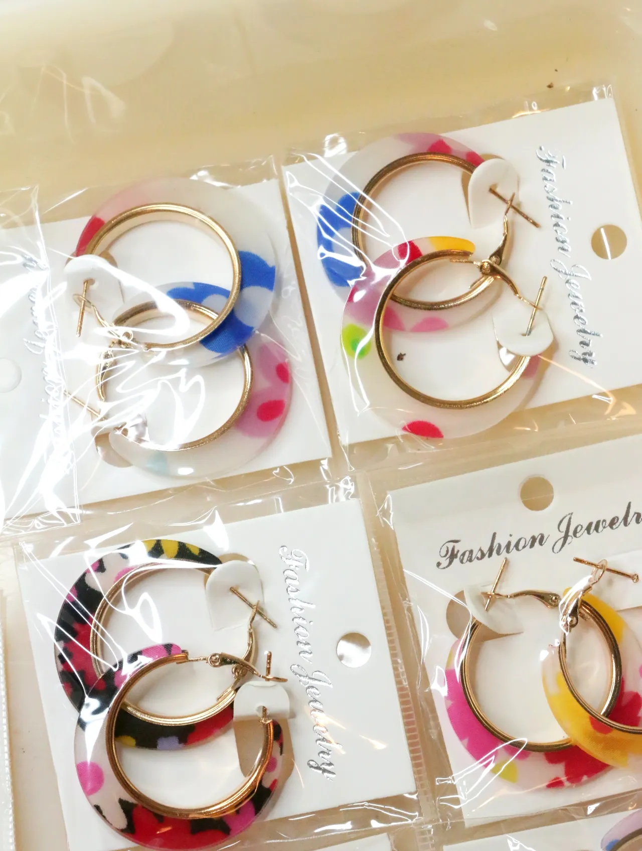 Pendientes de aro con flores en envoltorios transparentes — lote de bisutería de moda, vista lateral · Lotes Bisutería (H0008)