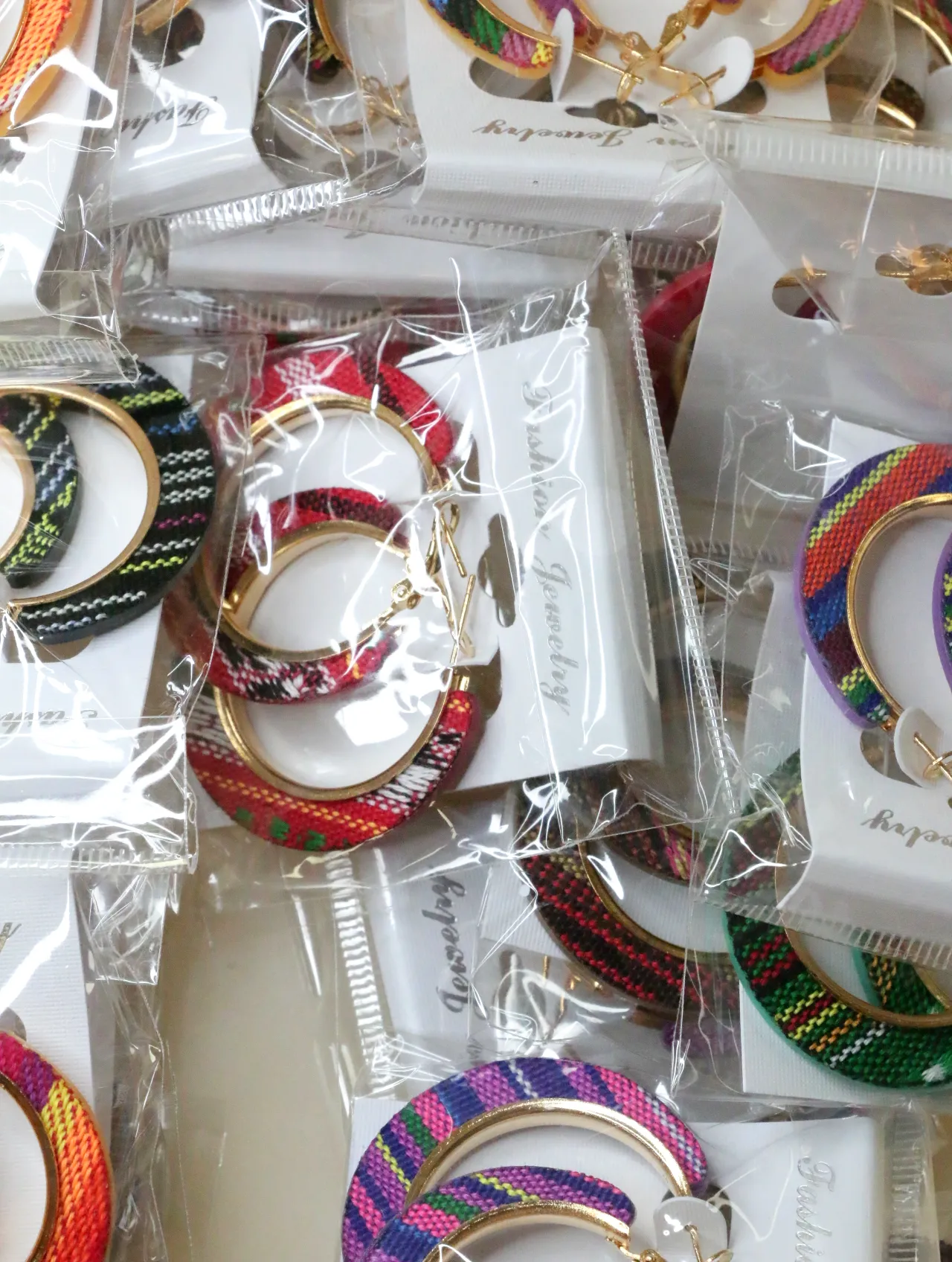 Aros en tono dorado con tejido multicolor envasados — lote de bisutería baratos, detalle · Lotes Bisutería (H0010)