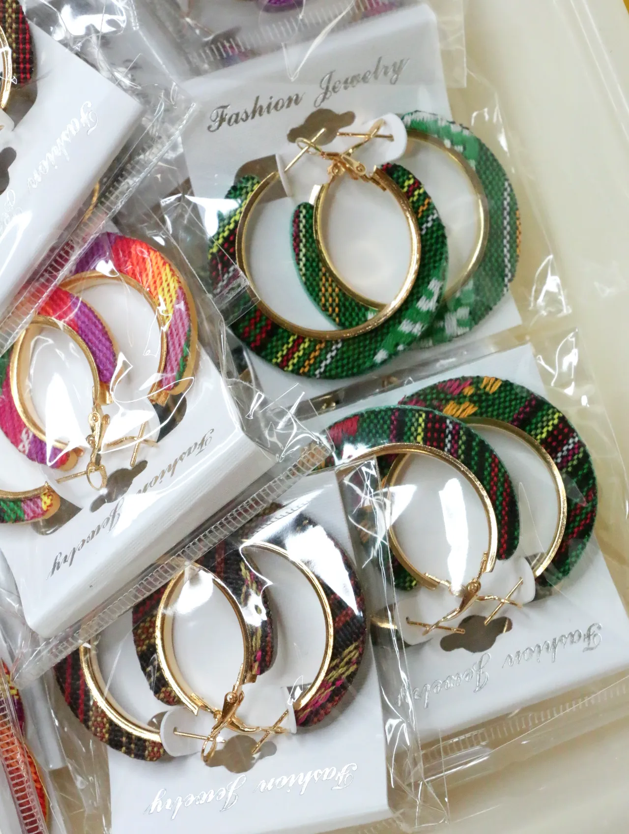 Aros de tejido estampado verde con bordes en tono dorado — lote de bisutería de moda, vista lateral · Lotes Bisutería (H0010)
