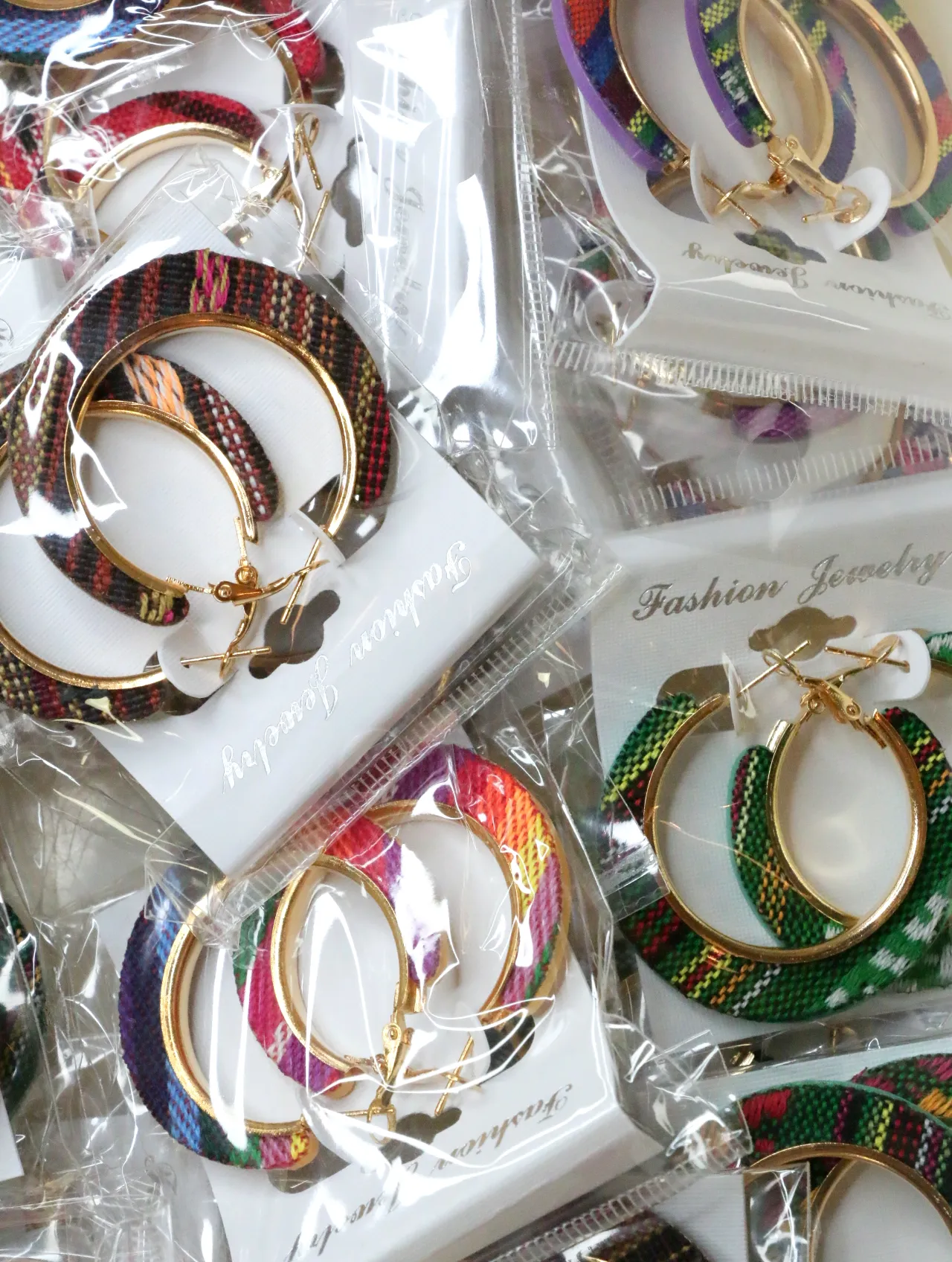 Surtido de pendientes de aro boho de tejido en envoltorios transparentes — lote de bisutería originales, detalle del acabado · Lotes Bisutería (H0010)