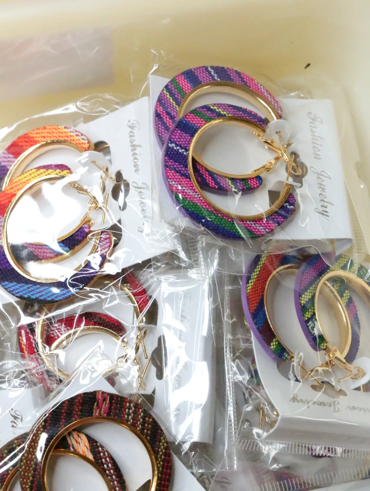 Pendientes de aro de tejido morado y multicolor sobre tarjetas — lote de bisutería online, vista principal · Lotes Bisutería (H0010)