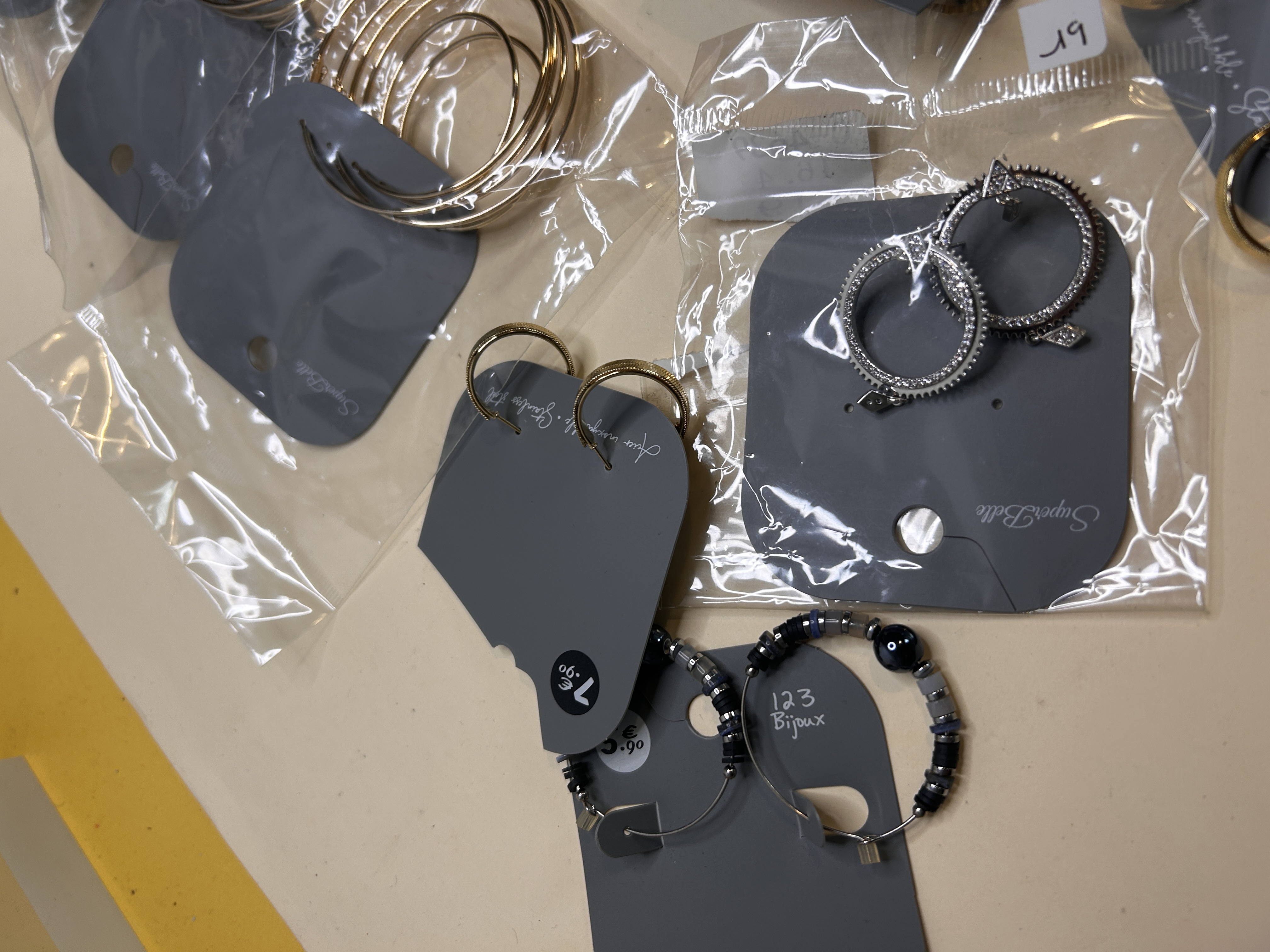 Detalle de aros decorados y con cuentas sobre soporte — lote de pendientes de moda, vista lateral · Lotes Bisutería (HOOP-201)