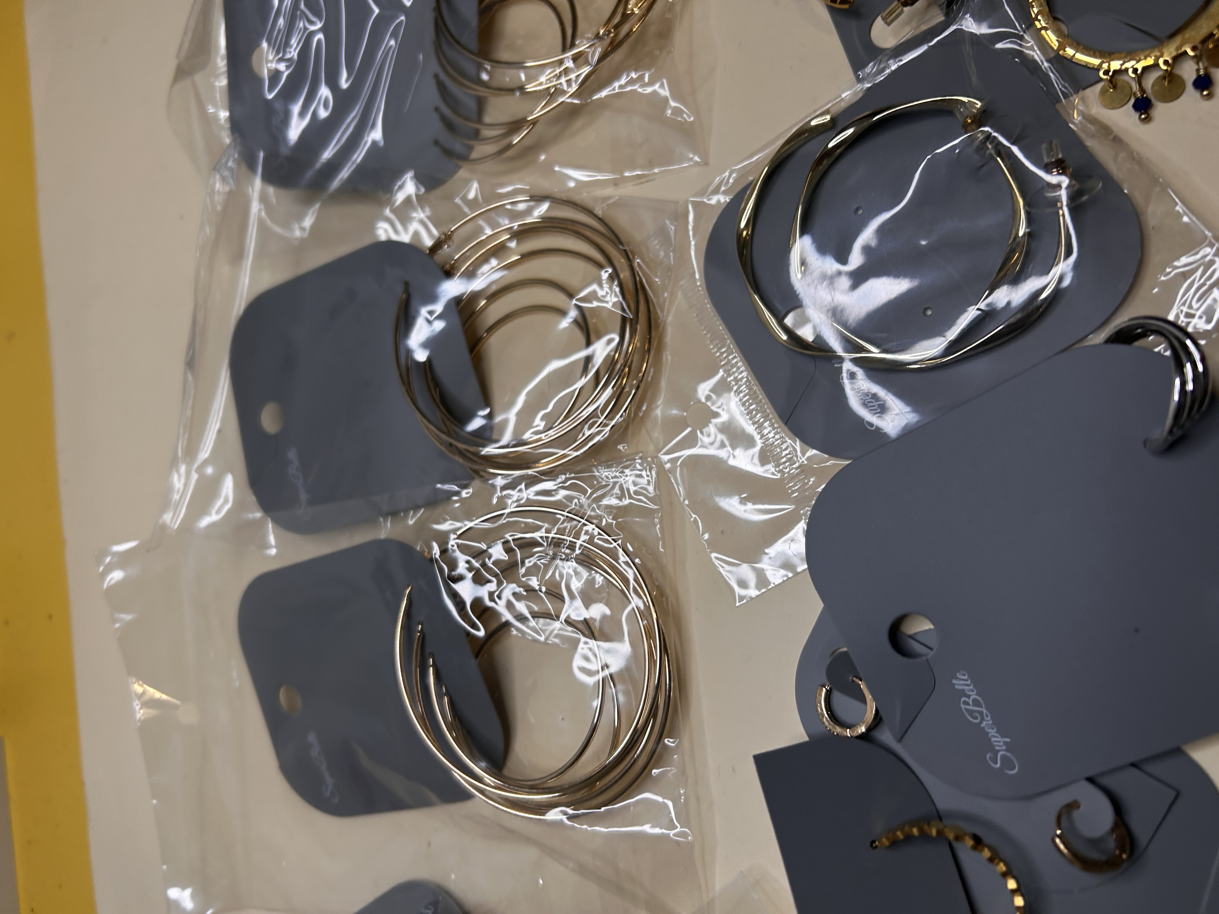 Primer plano de aros múltiples dorados embolsados — lote de pendientes originales, detalle del acabado · Lotes Bisutería (HOOP-201)