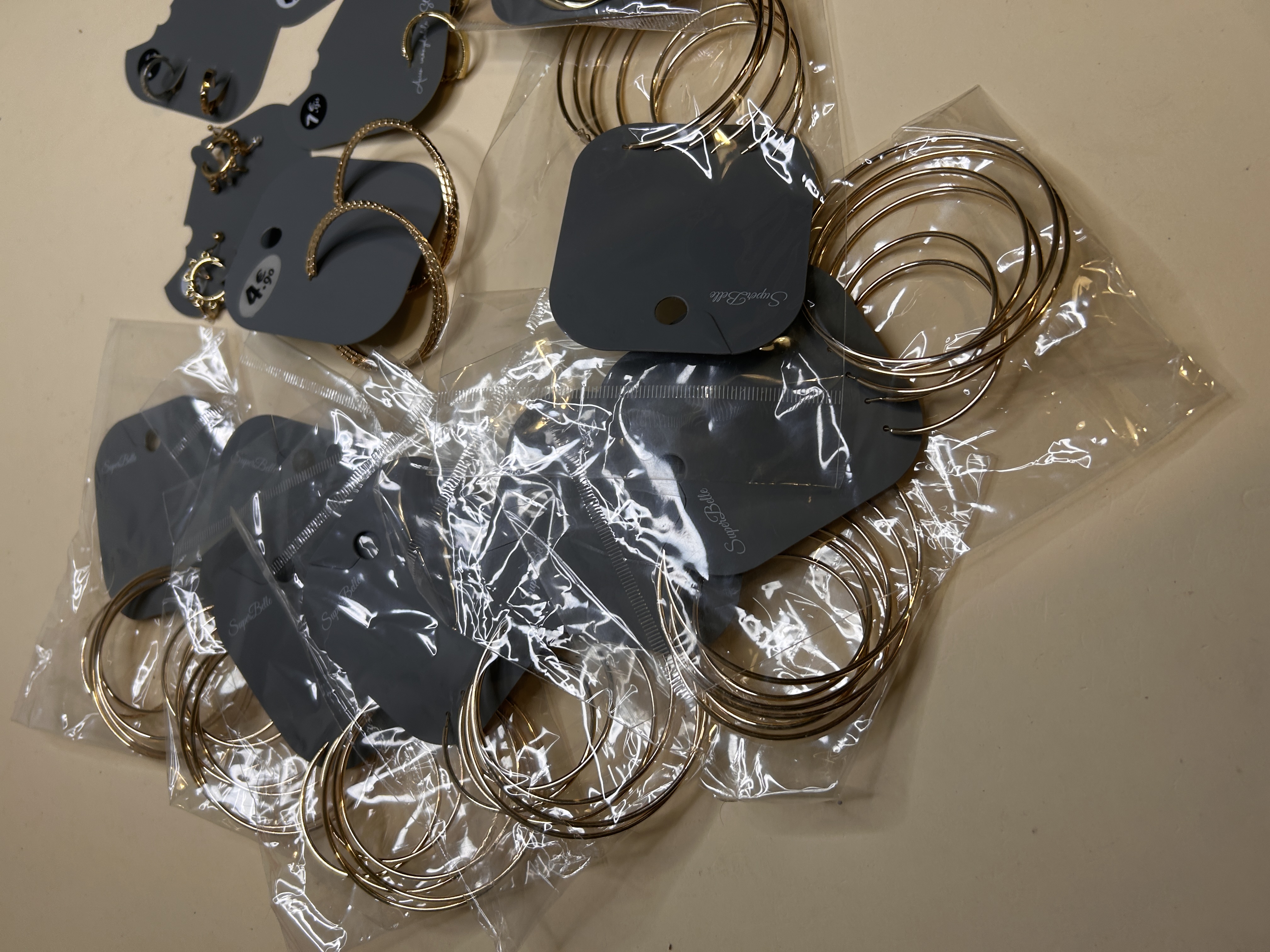Pila de pendientes de aros múltiples empaquetados — lote de pendientes dorados, primer plano · Lotes Bisutería (HOOP-202)