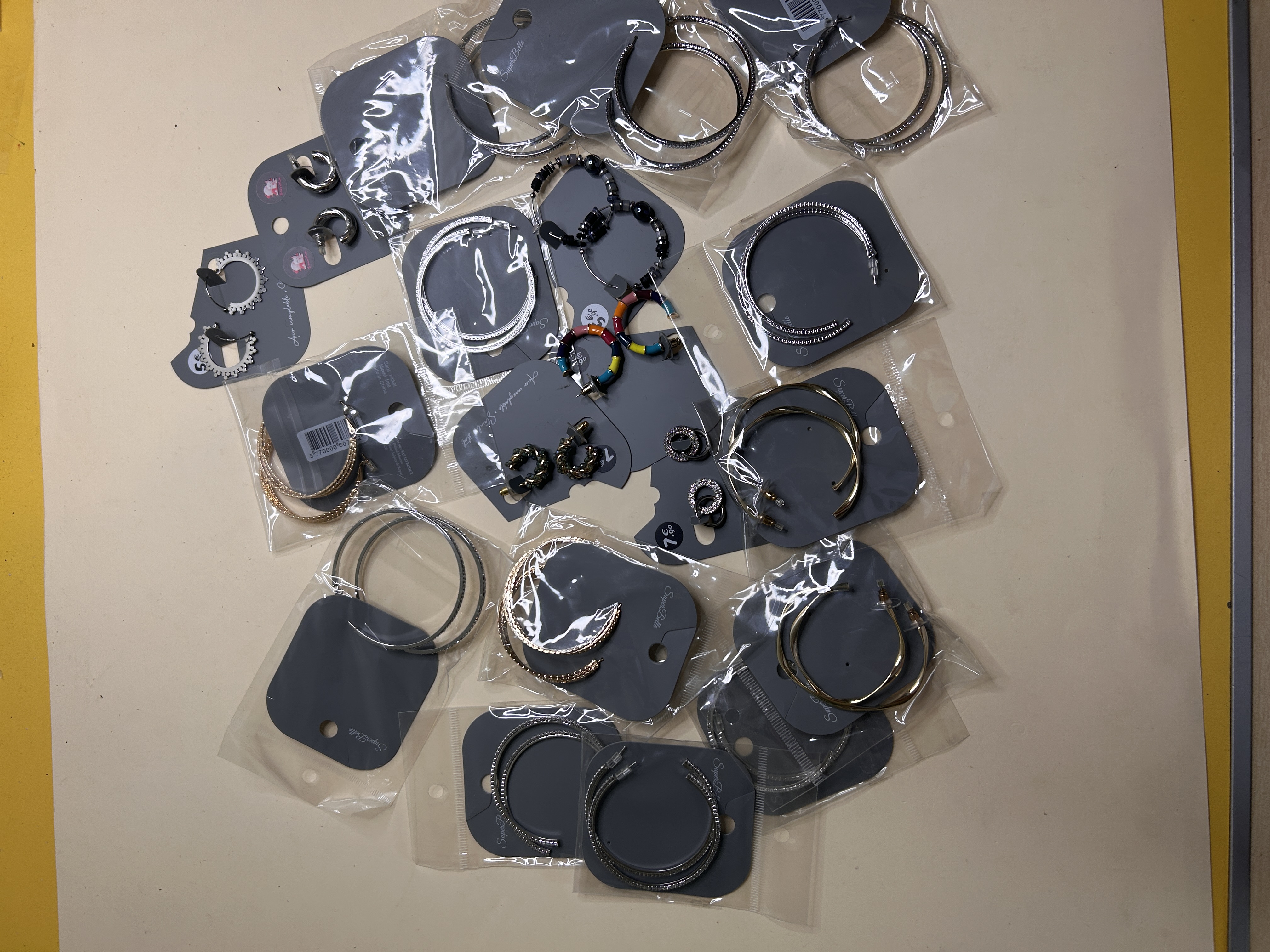 Variedad de pendientes de aro dorados y plateados sobre fondo blanco — lote de pendientes baratos, detalle · Lotes Bisutería (HOOP-204)