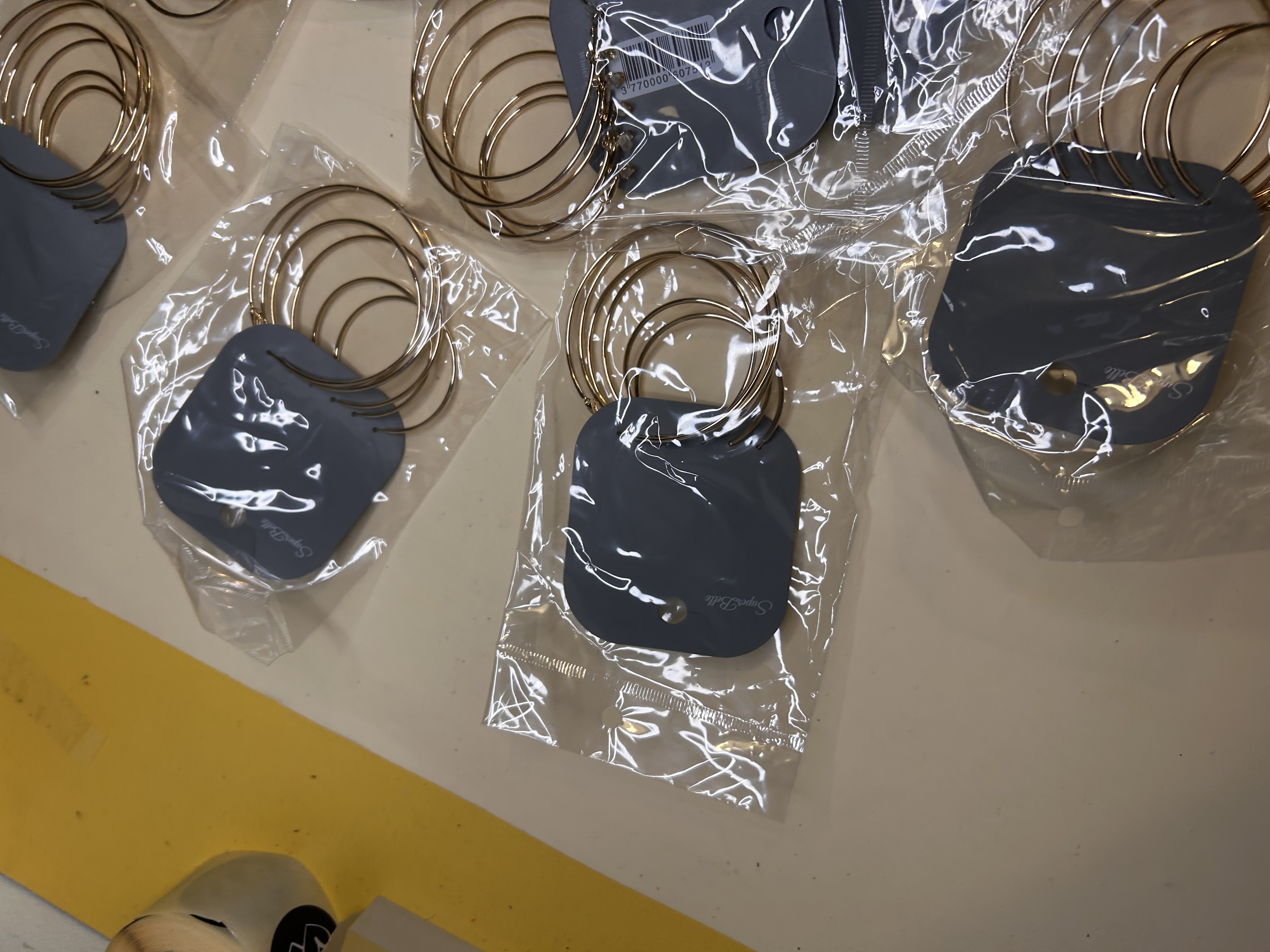 Vista cercana de pendientes de aro dorados en presentación de tienda — lote de pendientes de moda, vista lateral · Lotes Bisutería (HOOP-205)