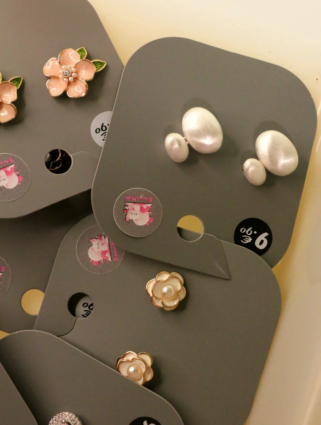 Pendientes ovalados efecto perla junto a diseños florales — lote de bisutería de moda, vista lateral · Lotes Bisutería (LOLA-P-BC-001)