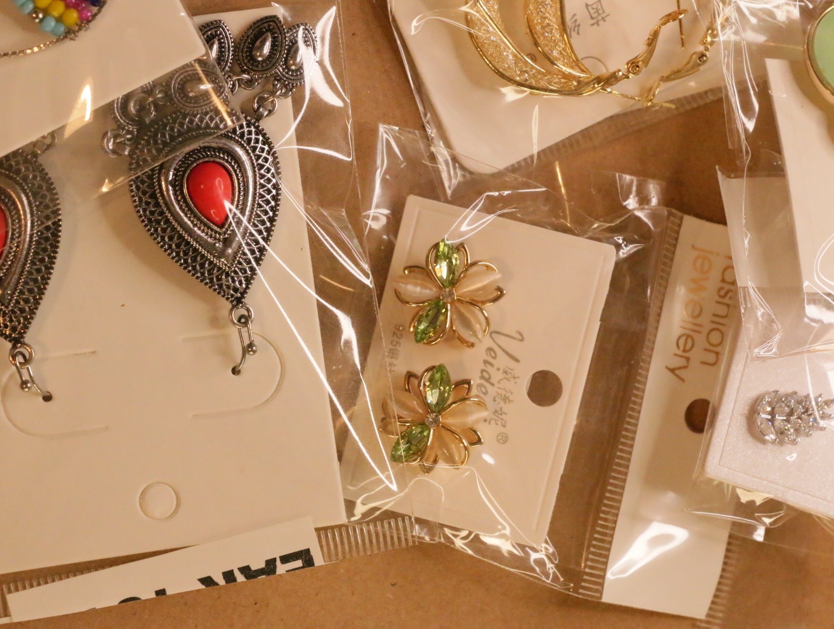 Pendientes florales y colgantes plateados con detalles rojos — lote de bisutería online, vista principal · Lotes Bisutería (LT040)