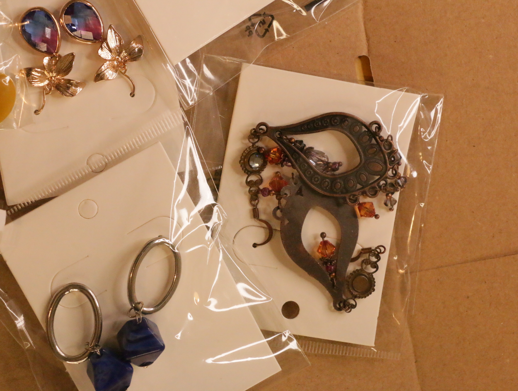 Pendientes ornamentales envejecidos junto a diseños colgantes morados y azules — lote de bisutería de moda, vista lateral · Lotes Bisutería (LT041)