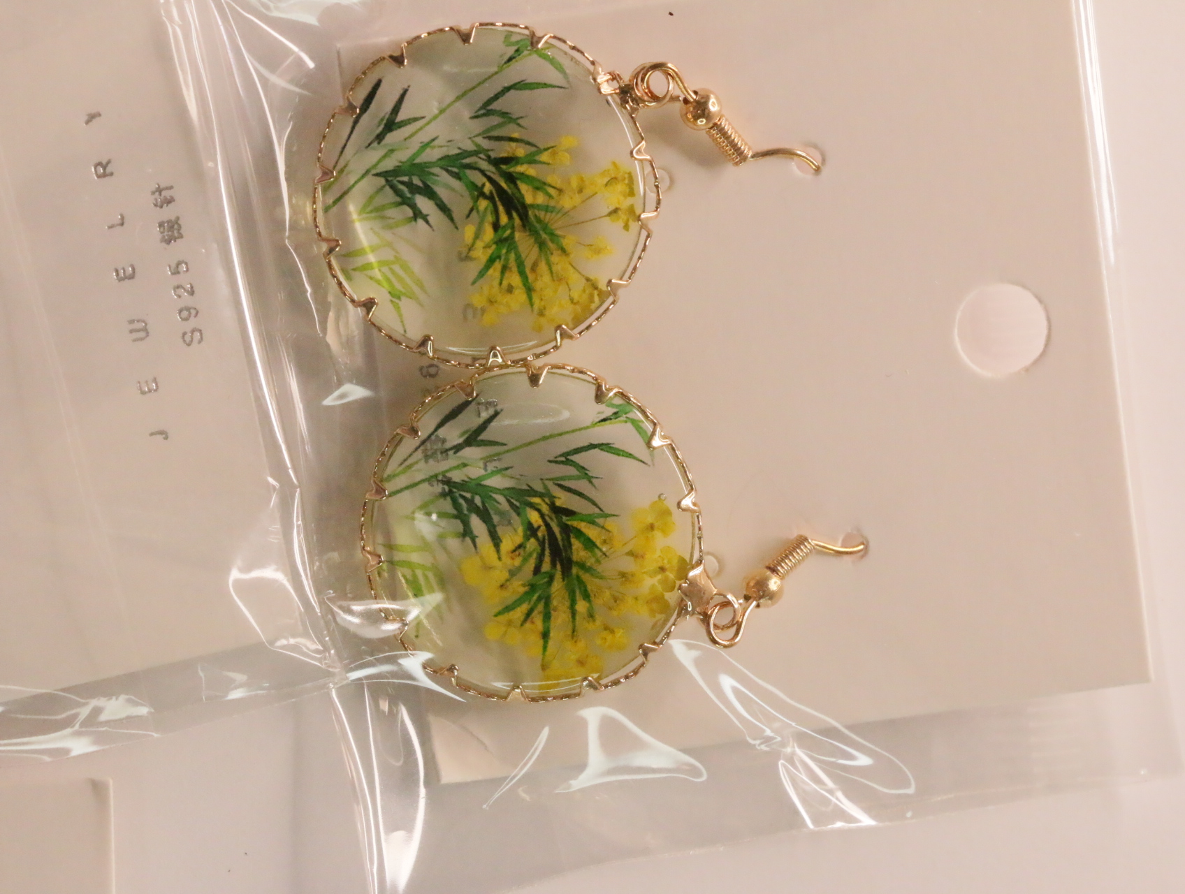 Pendientes redondos transparentes con flores amarillas y follaje verde — lote de bisutería dorados, primer plano · Lotes Bisutería (LT046)