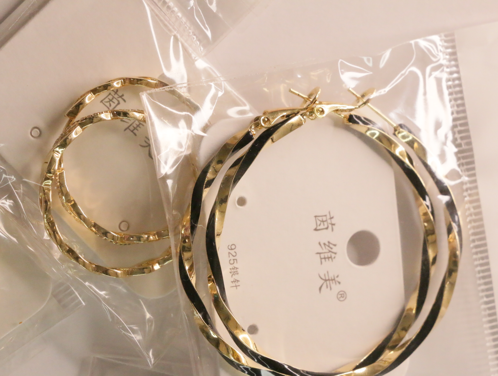 Pendientes de aro retorcidos en dorado con detalles negros — lote de bisutería de moda, vista lateral · Lotes Bisutería (LT047)