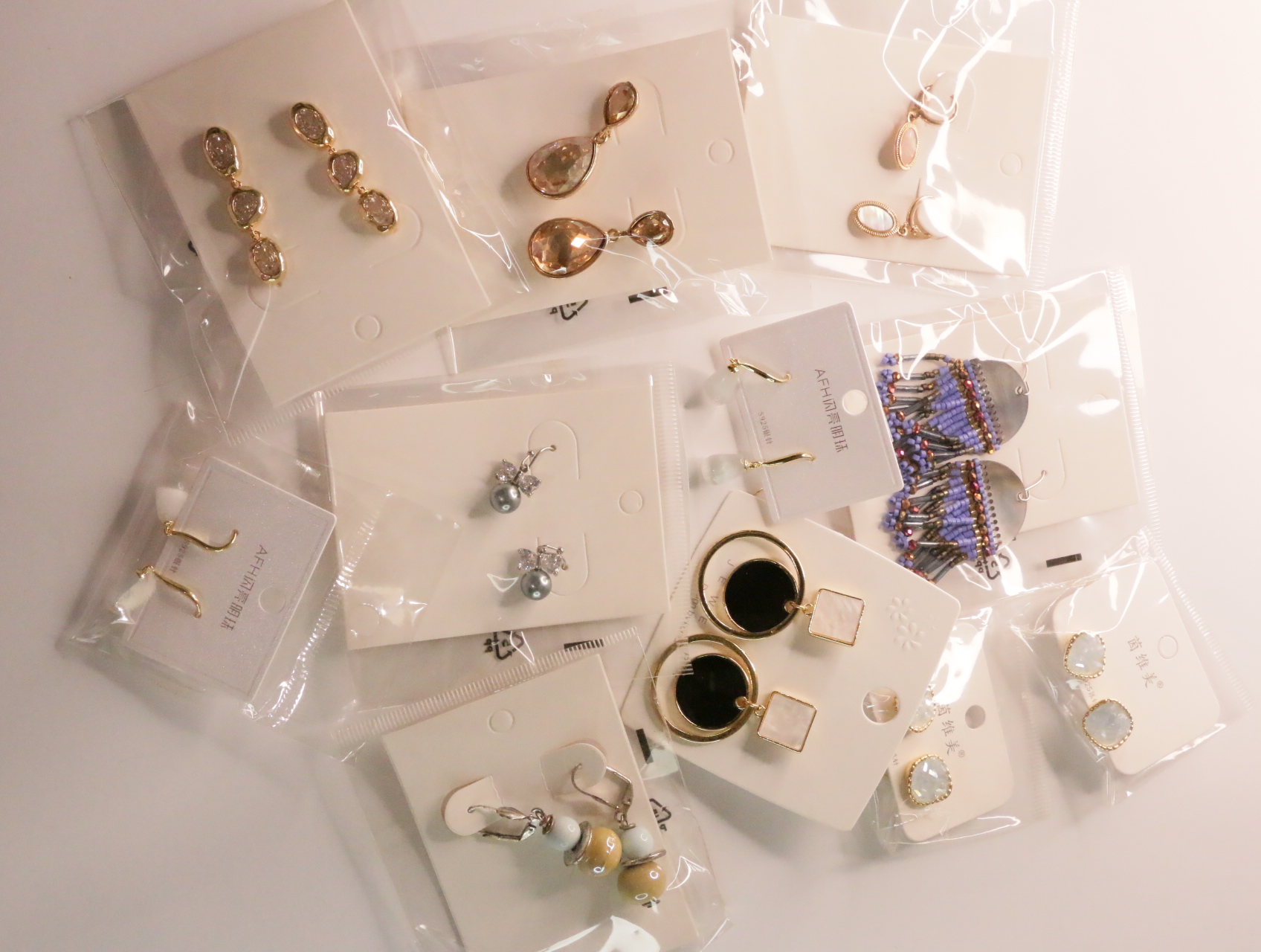 Vista general de pendientes variados con acabados metálicos y detalles de colores — lote de bisutería para mujer, vista principal · Lotes Bisutería (LT048)