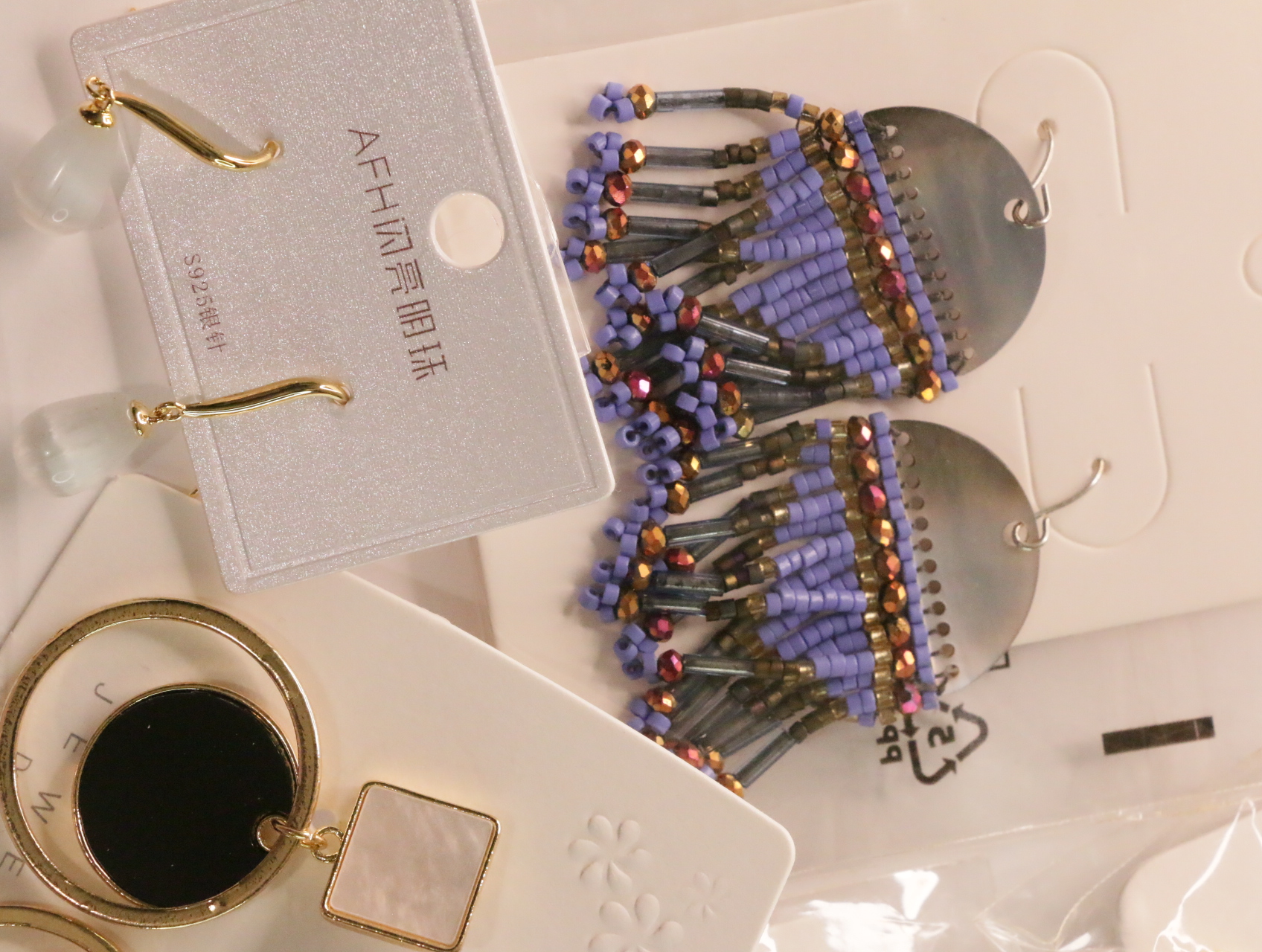 Pendientes boho con flecos de cuentas lilas junto a diseños geométricos — lote de bisutería dorados, primer plano · Lotes Bisutería (LT048)