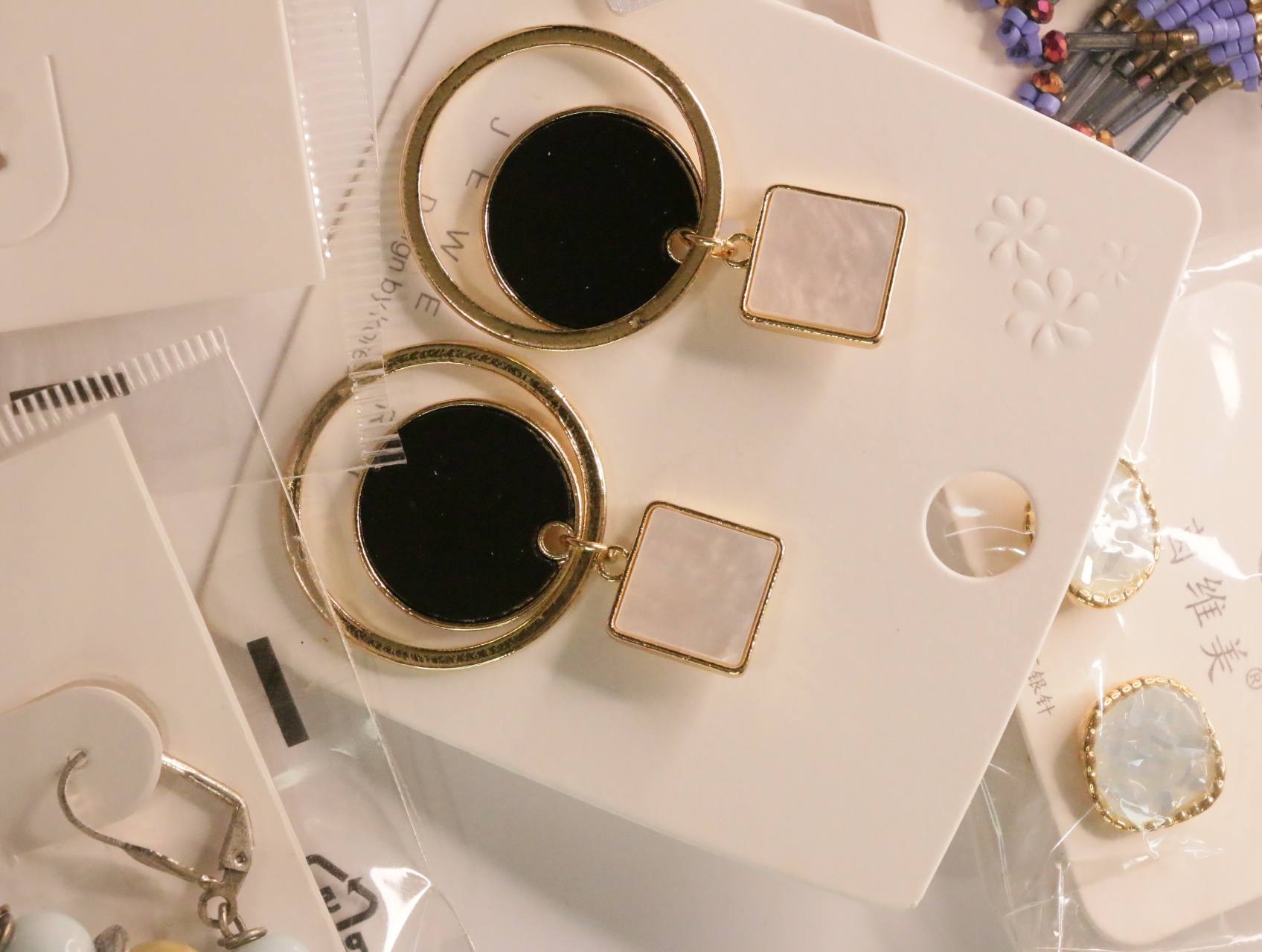 Pendientes geométricos con aros dorados y discos negros — lote de bisutería originales, detalle del acabado · Lotes Bisutería (LT048)