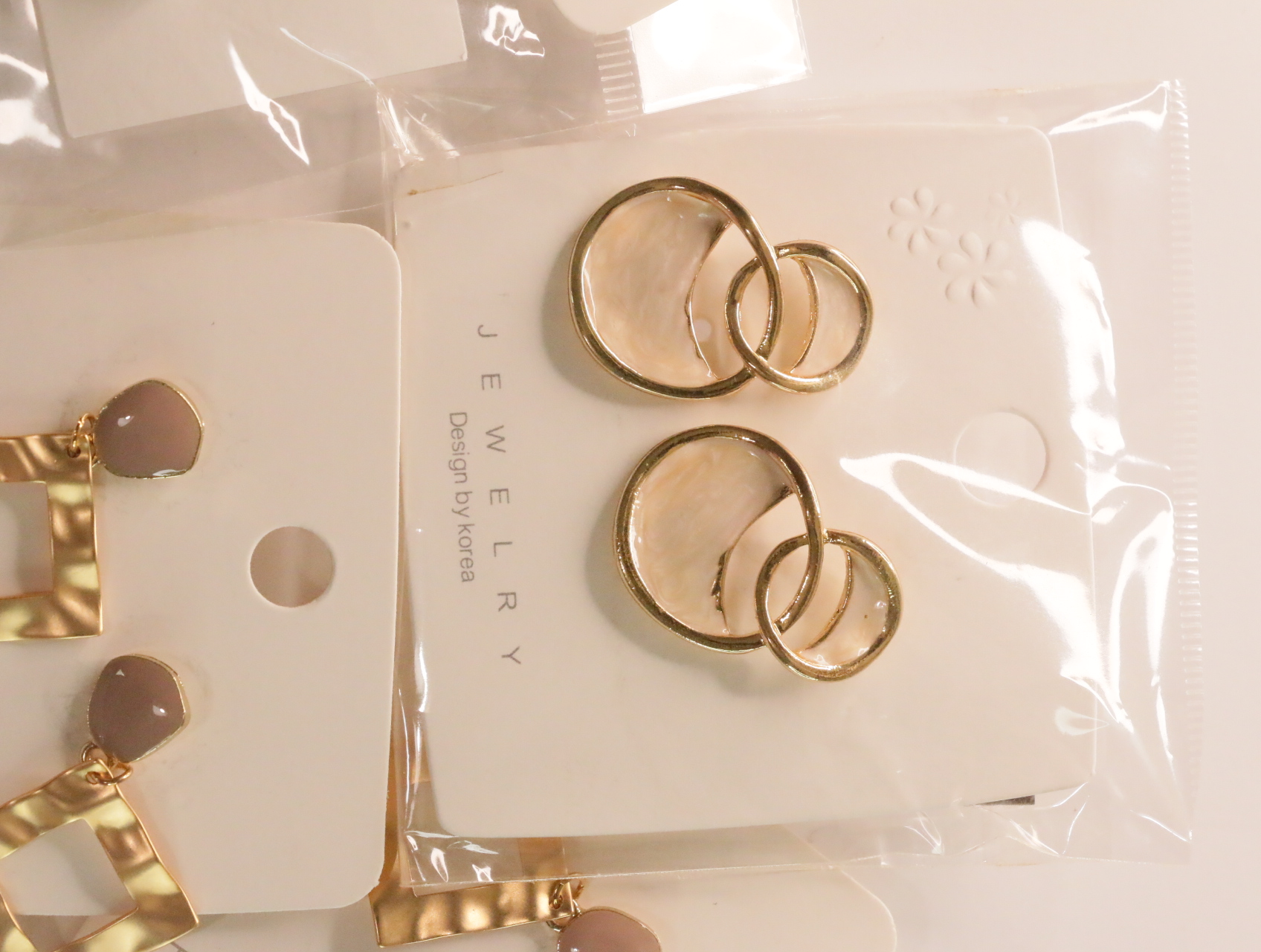 Pendientes de círculos enlazados dorados con detalles translúcidos claros — lote de bisutería de moda, vista lateral · Lotes Bisutería (LT049)