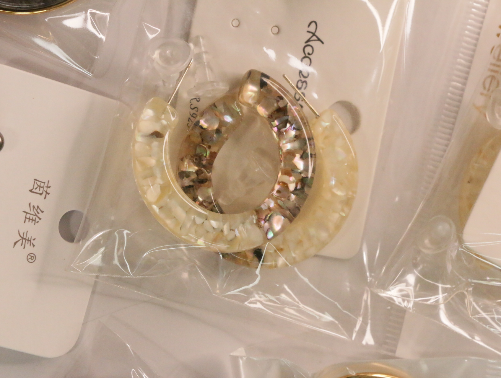 Pendientes de aro color crema con efectos decorativos nacarados — lote de bisutería originales, detalle del acabado · Lotes Bisutería (LT050)