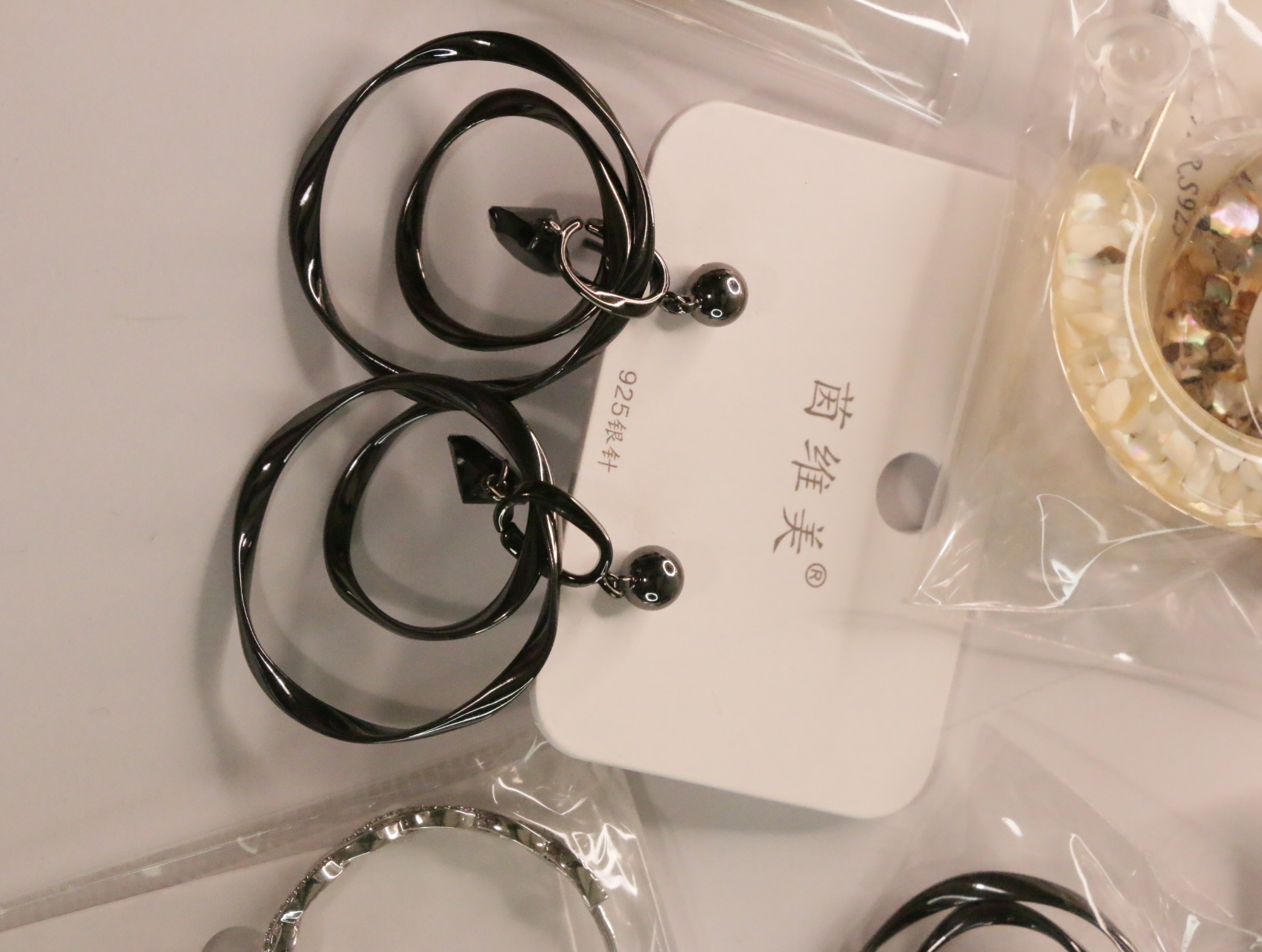 Pendientes colgantes negros brillantes con anillas entrelazadas — lote de bisutería online, vista principal · Lotes Bisutería (LT050)