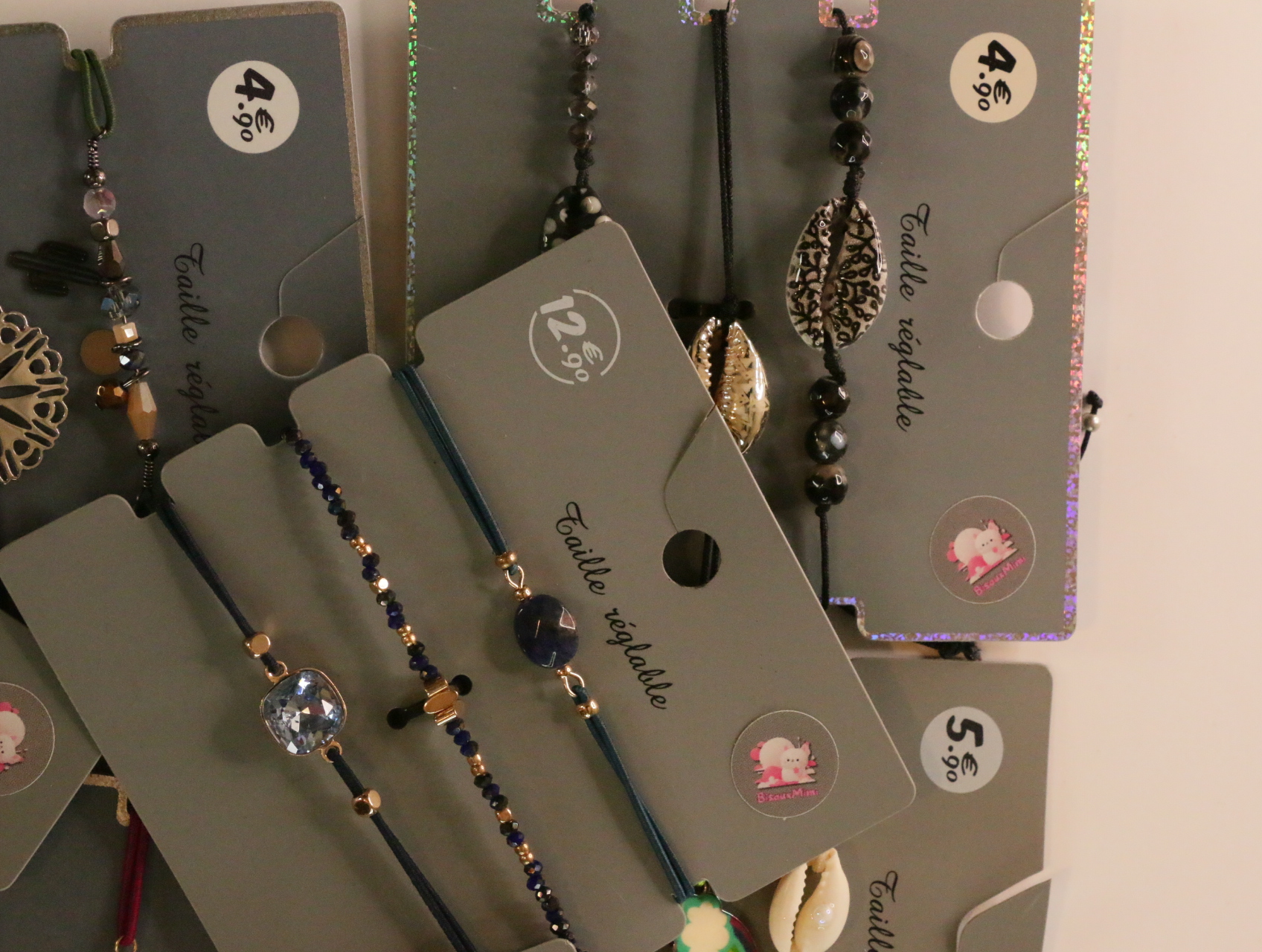 Detalle de pulseras de cordón con cuentas y adornos metálicos — lote de bisutería dorados, primer plano · Lotes Bisutería (LT053)
