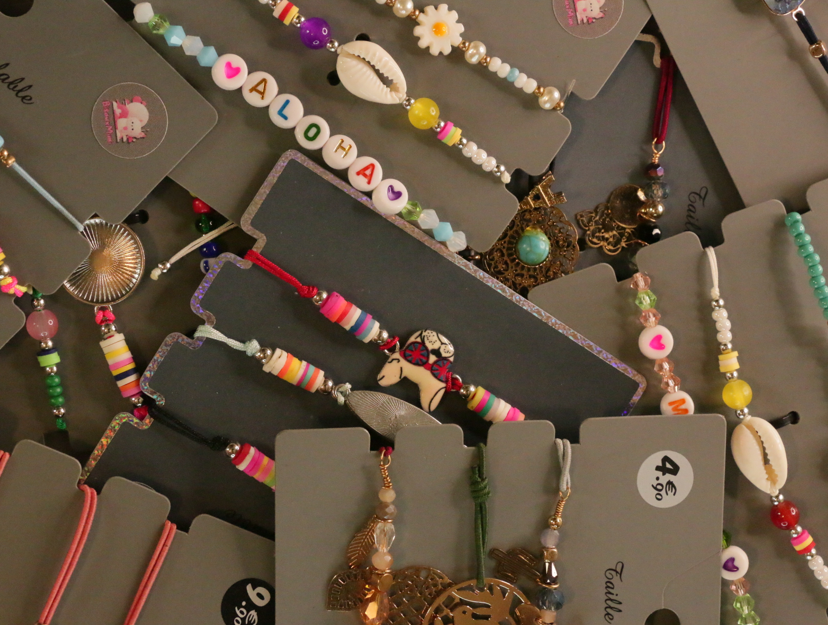 Detalle de pulseras de cuentas con corazones y colgantes decorativos — lote de bisutería online, vista principal · Lotes Bisutería (LT053)