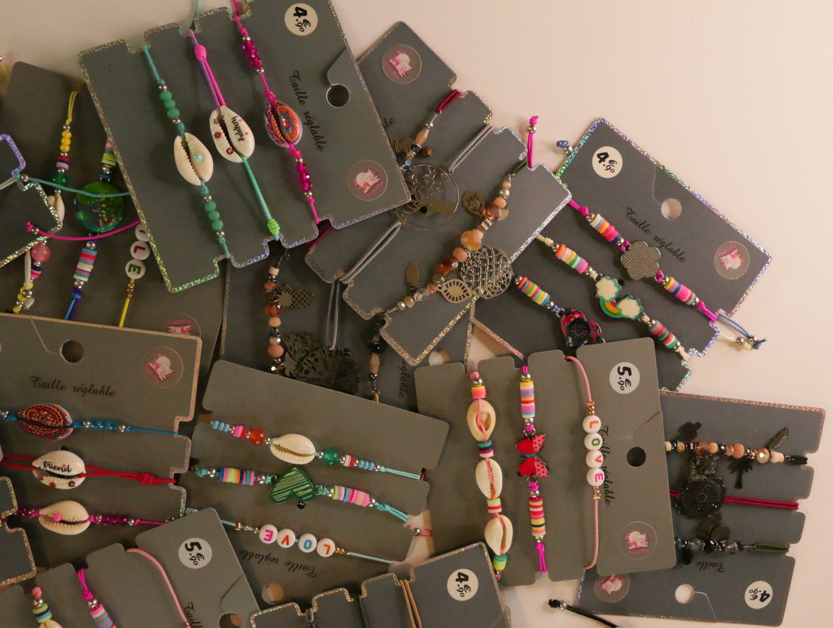 Pulseras con cordones de colores, conchas y colgantes metálicos — lote de bisutería dorados, primer plano · Lotes Bisutería (LT054)