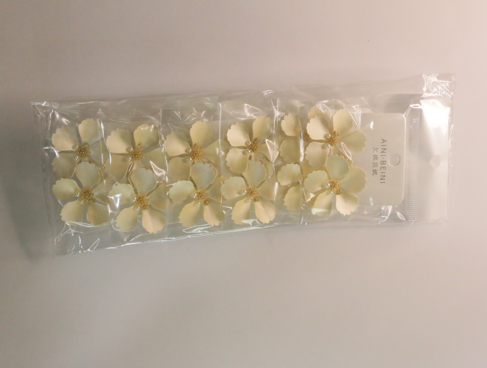 Vista del lote completo de pendientes de flores crema en sus envoltorios — lote de bisutería para mujer, vista principal · Lotes Bisutería (LT058)