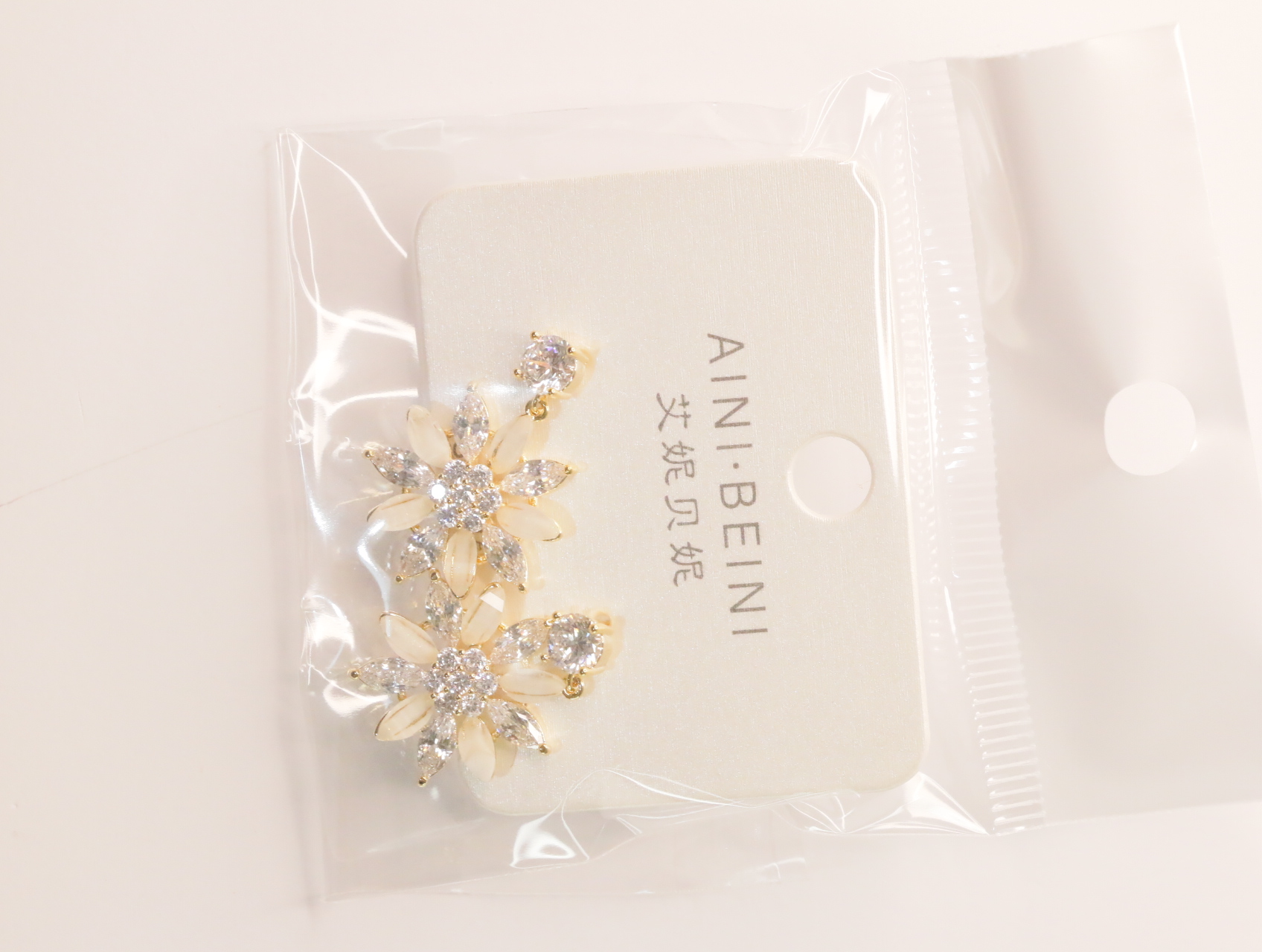 Pendientes florales con pétalos crema y detalles brillantes sobre tarjeta — lote de bisutería baratos, detalle · Lotes Bisutería (LT060)
