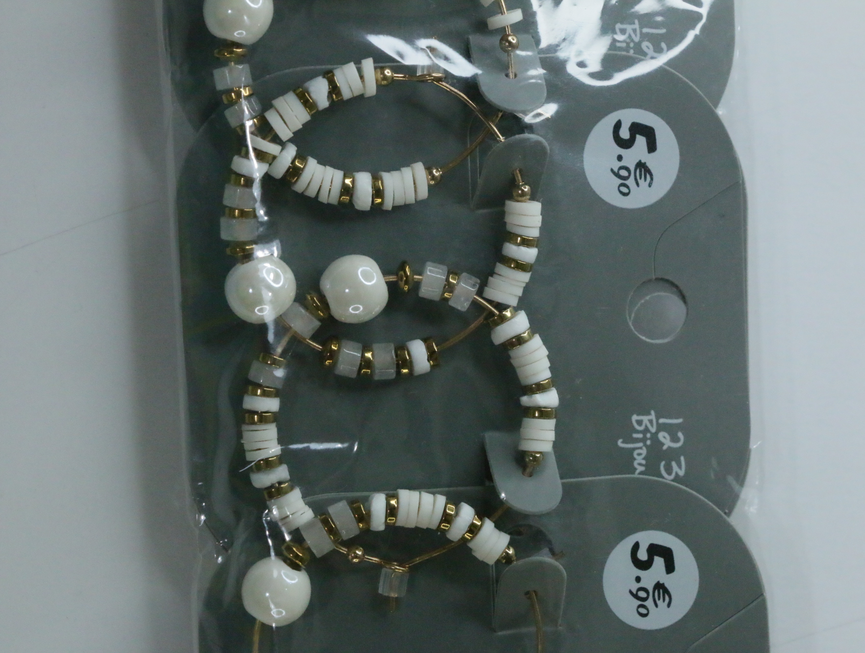 Detalle de los aros con cuentas blancas y detalles dorados — lote de bisutería dorados, primer plano · Lotes Bisutería (LT068)