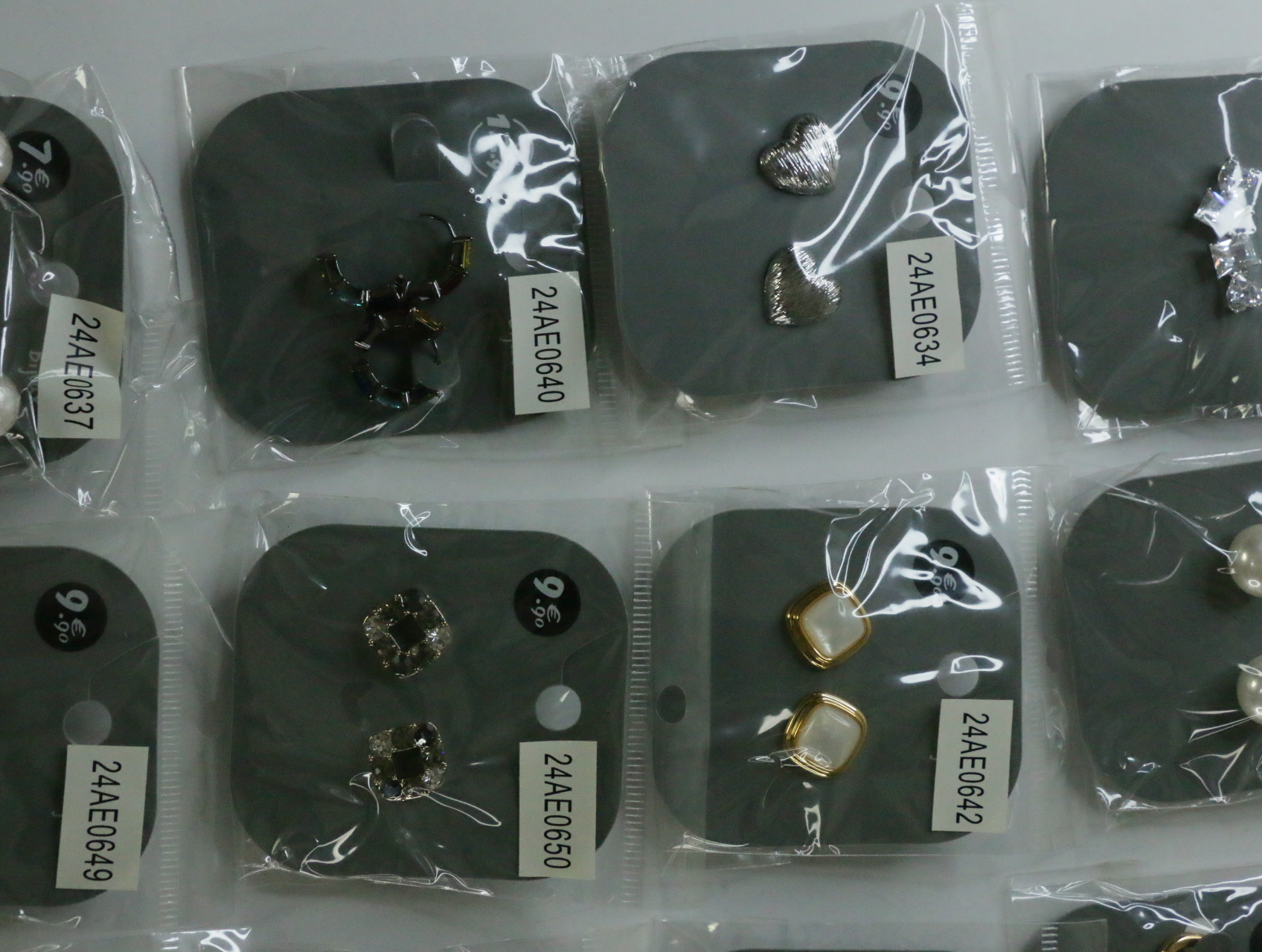 Pendientes plateados texturizados junto a diseños oscuros y nacarados — lote de bisutería originales, detalle del acabado · Lotes Bisutería (LT070)