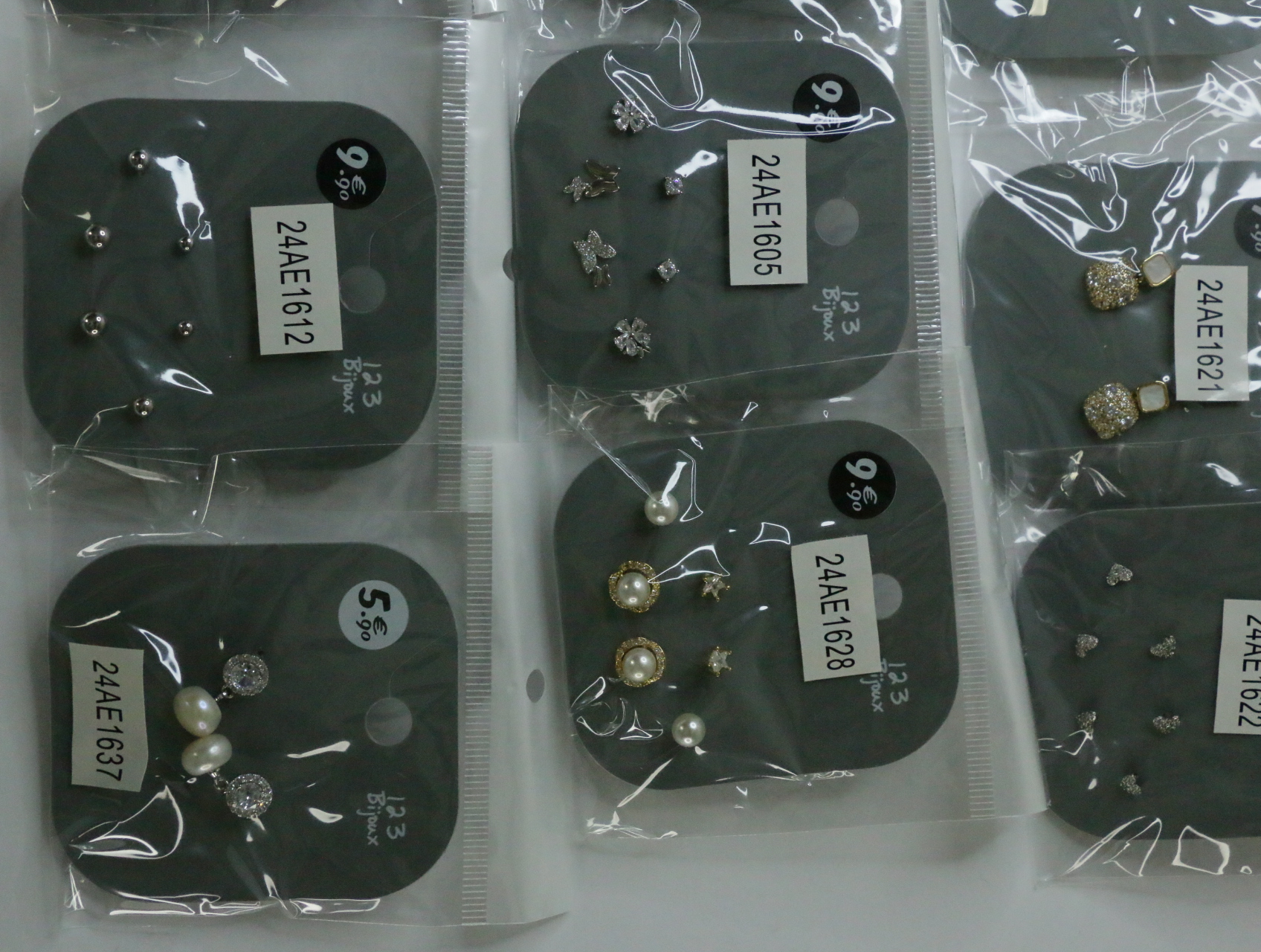 Pendientes plateados y de efecto perla en envoltorios protectores — lote de bisutería de moda, vista lateral · Lotes Bisutería (LT072)