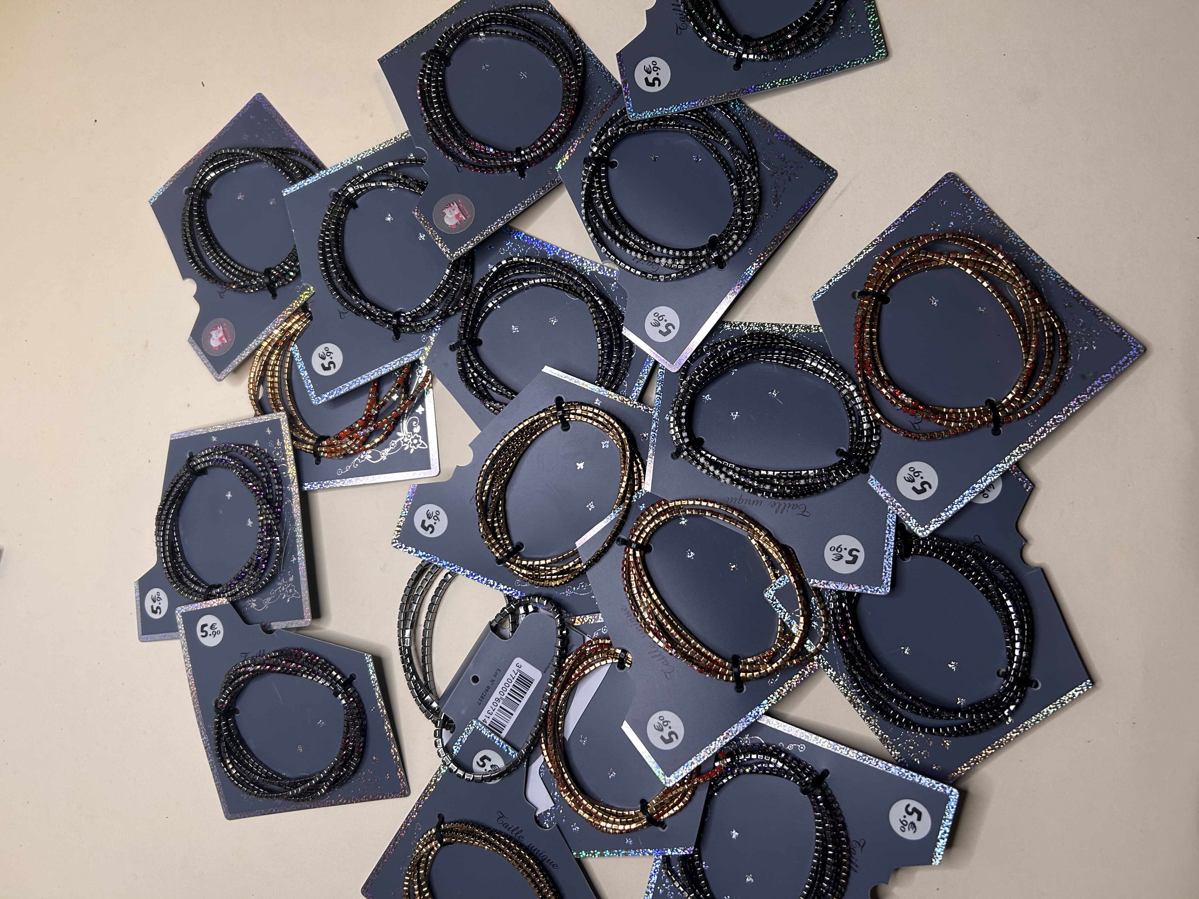 Primer plano de una variedad de pulseras de cuentas flexibles en diferentes tonos metálicos