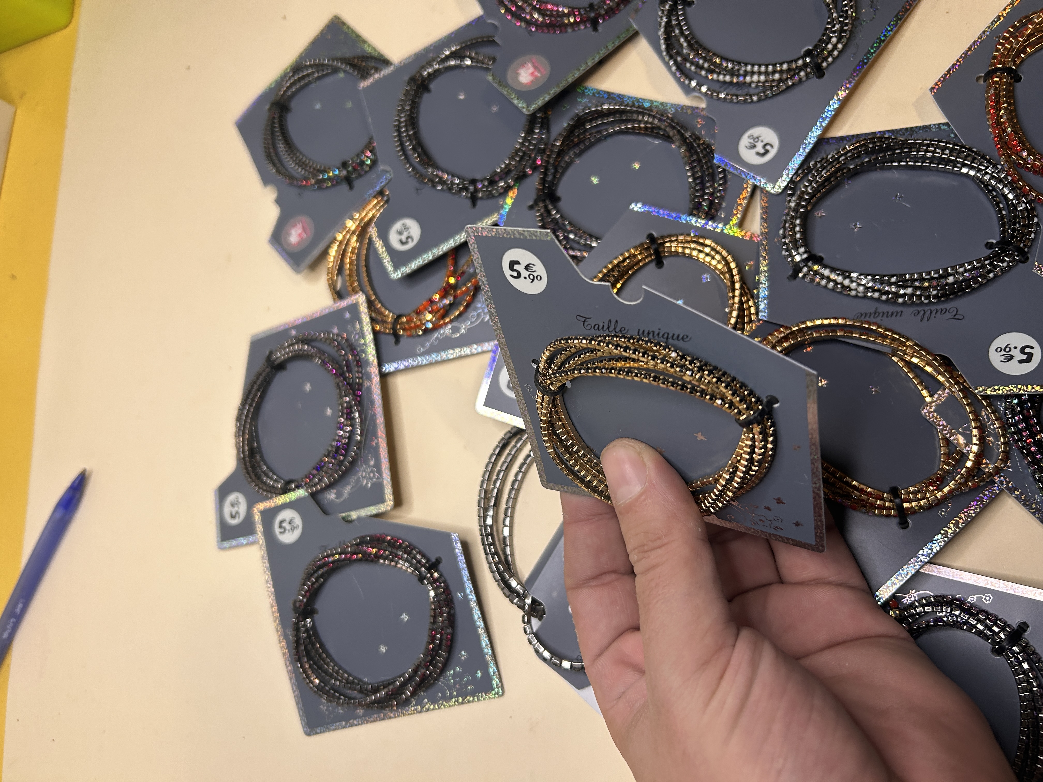 Mano sosteniendo una pulsera de cuentas doradas del lote al por mayor